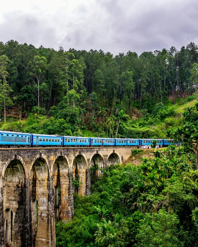Un train bleu sur un viaduc de pierre au Sri Lanka