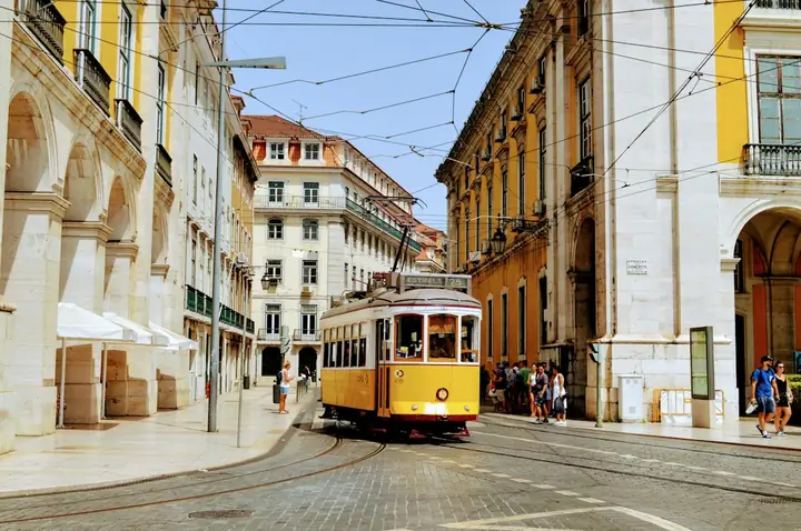 Photo : Aayush Gupta / Unsplash Un tramway jaune dans une rue de Lisbonne
