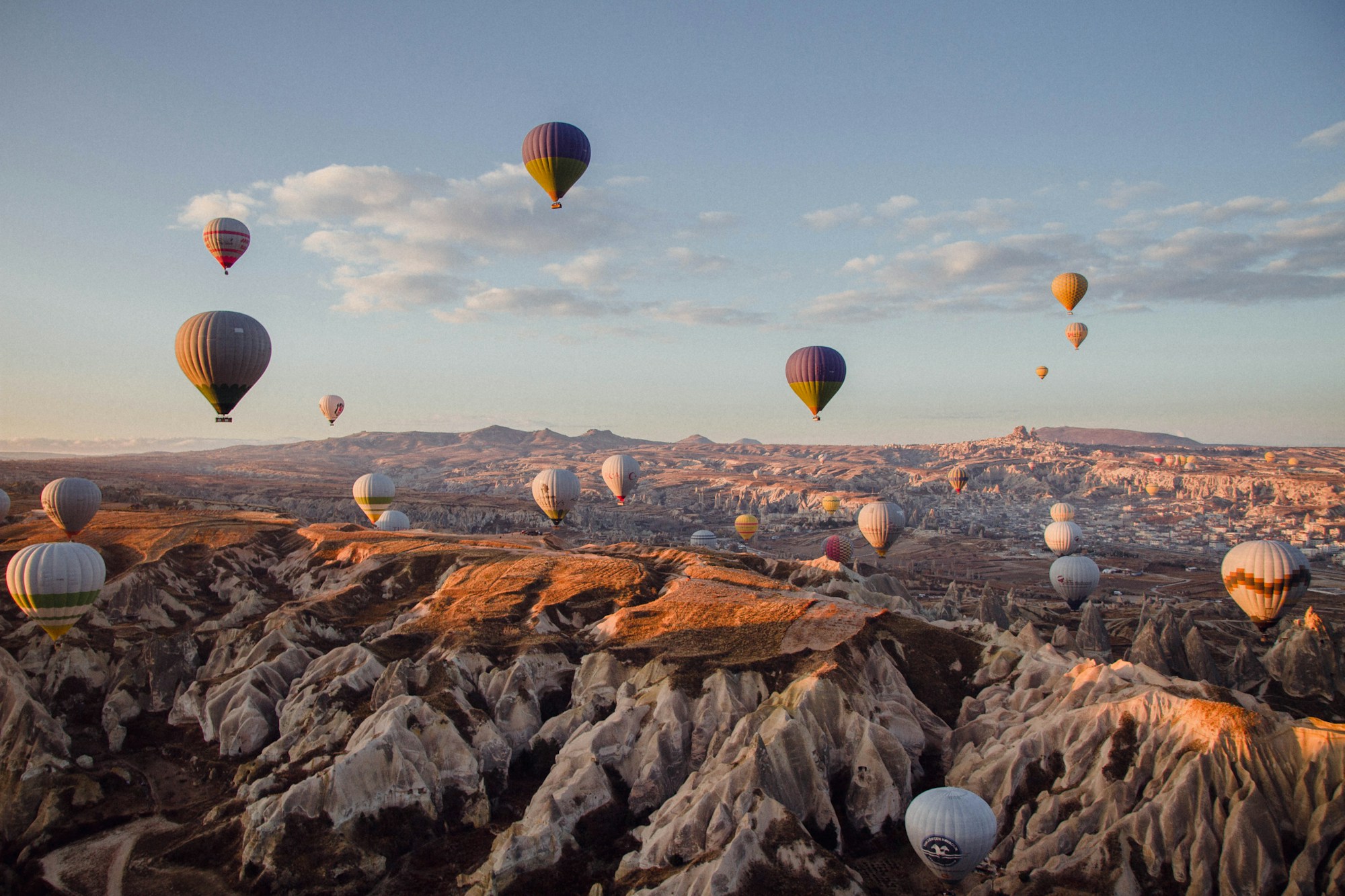 Hot air balloons flying over Cappadocia's fairy chimneys at sunrise
