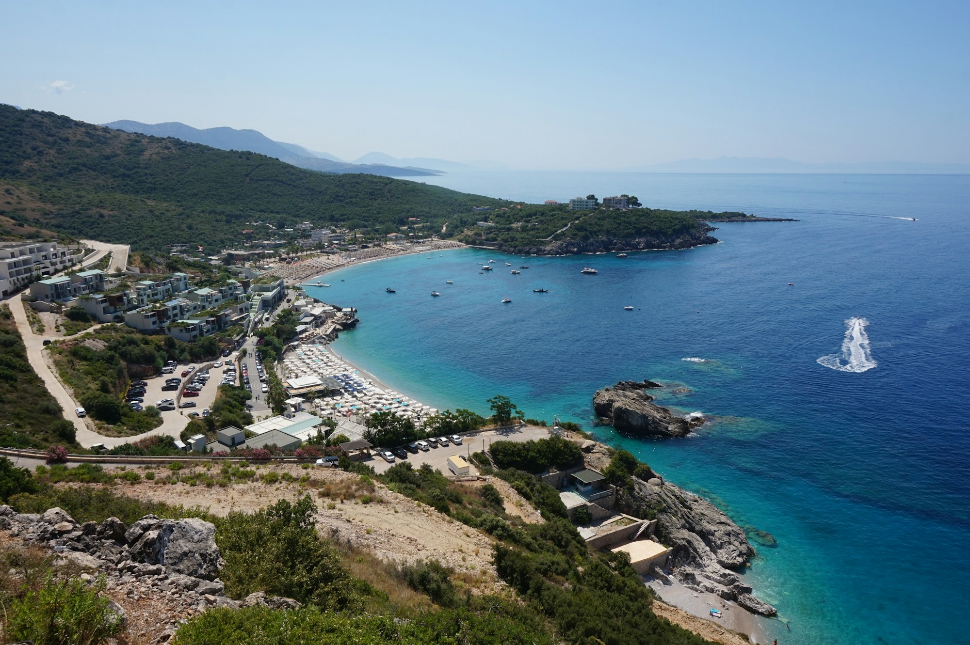 Jale Beach on the Albanian Riviera, turquoise water and lush green mountains in the background