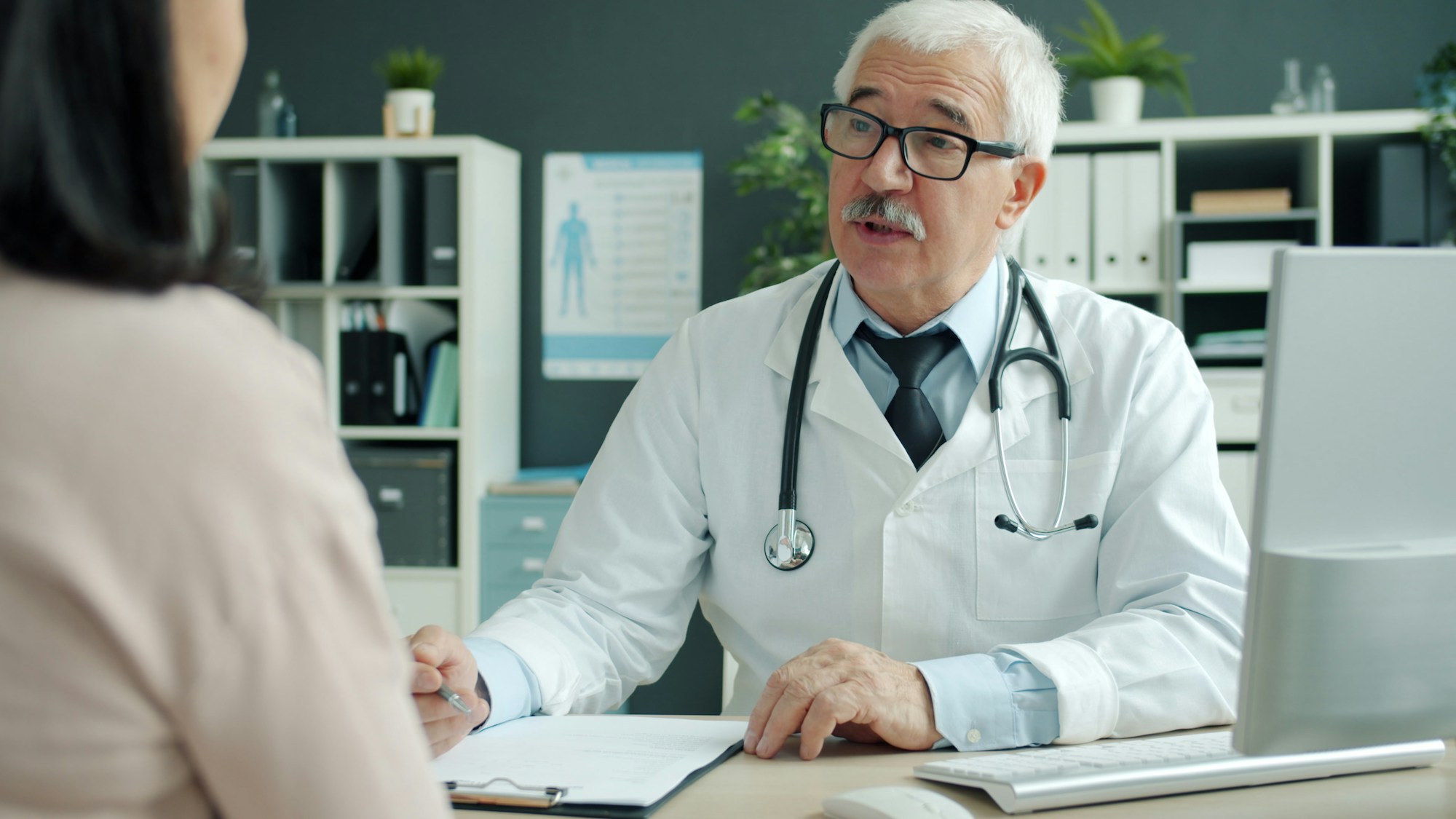 Consultation médicale à l'étranger : médecin senior discutant avec une patiente