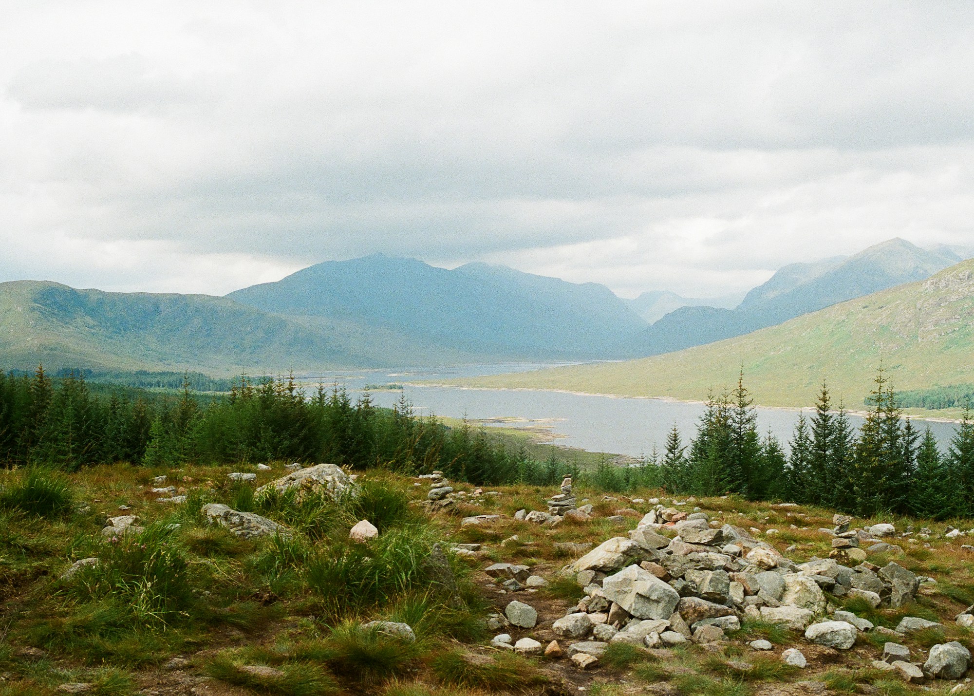 Scottish Highlands landscape with loch, mountains, and dramatic sky