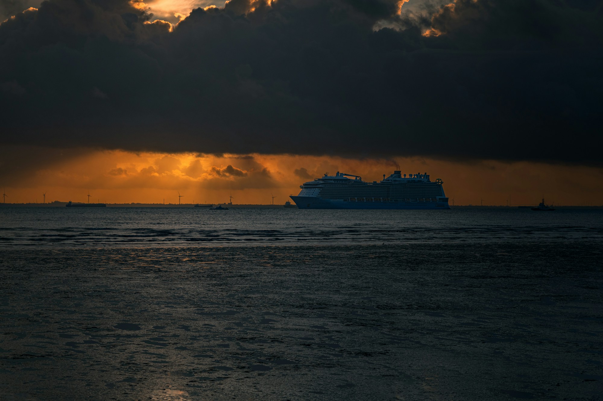 Cruise ship sailing at sunset on a calm ocean
