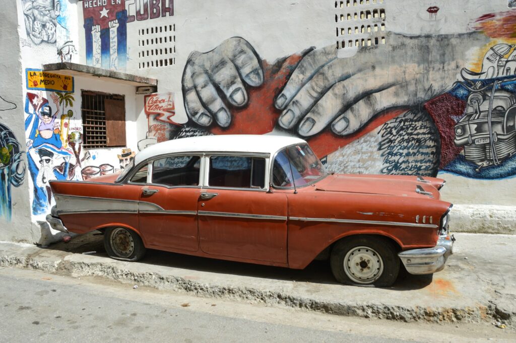 Voiture américaine classique des années 1950 devant un mural de street art à La Havane, Cuba