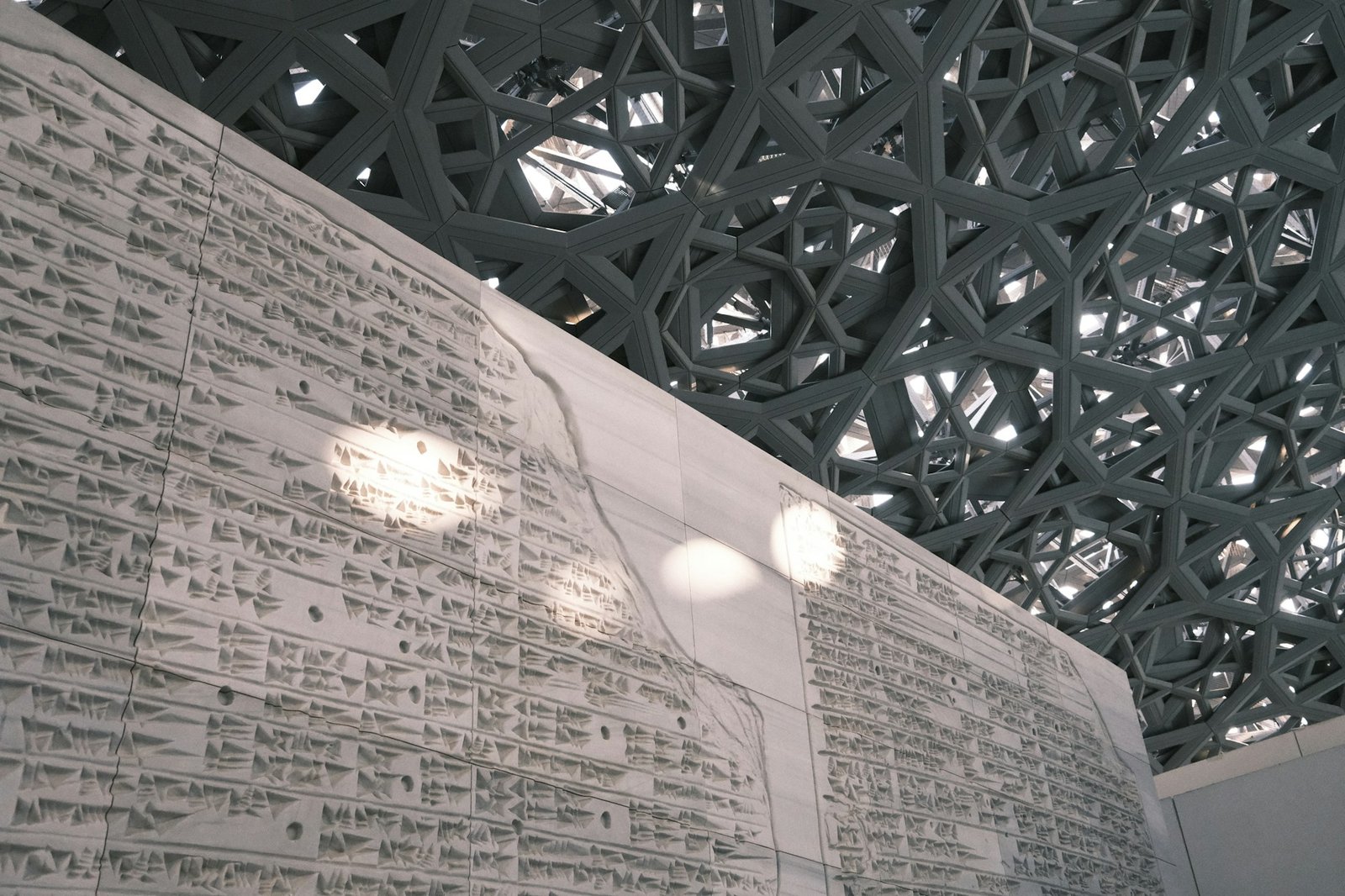 The Louvre Abu Dhabi on Saadiyat Island with its iconic honeycomb dome reflected in the water
