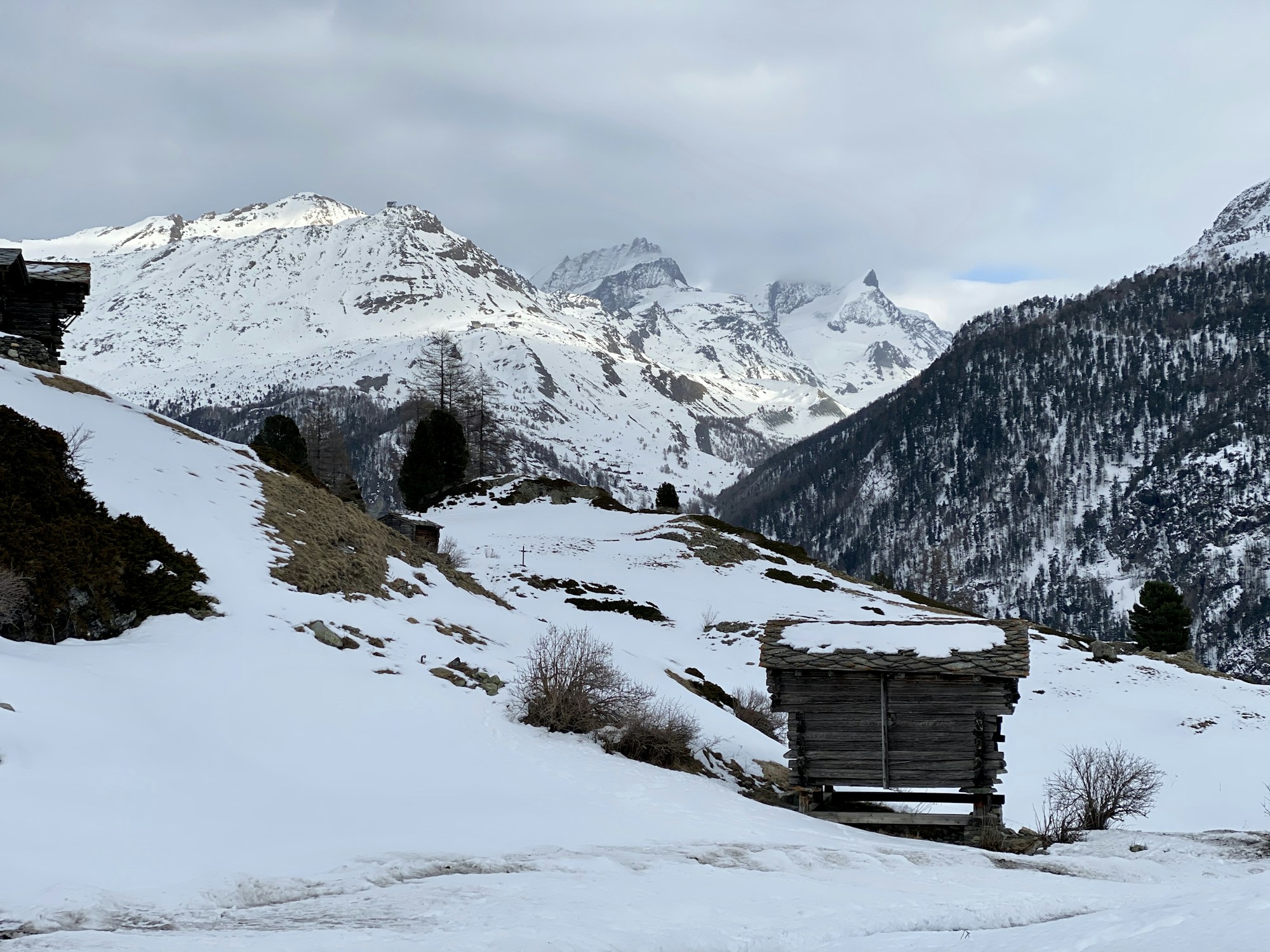 Wooden chalet in the Swiss Alps with snow-covered mountains in the background