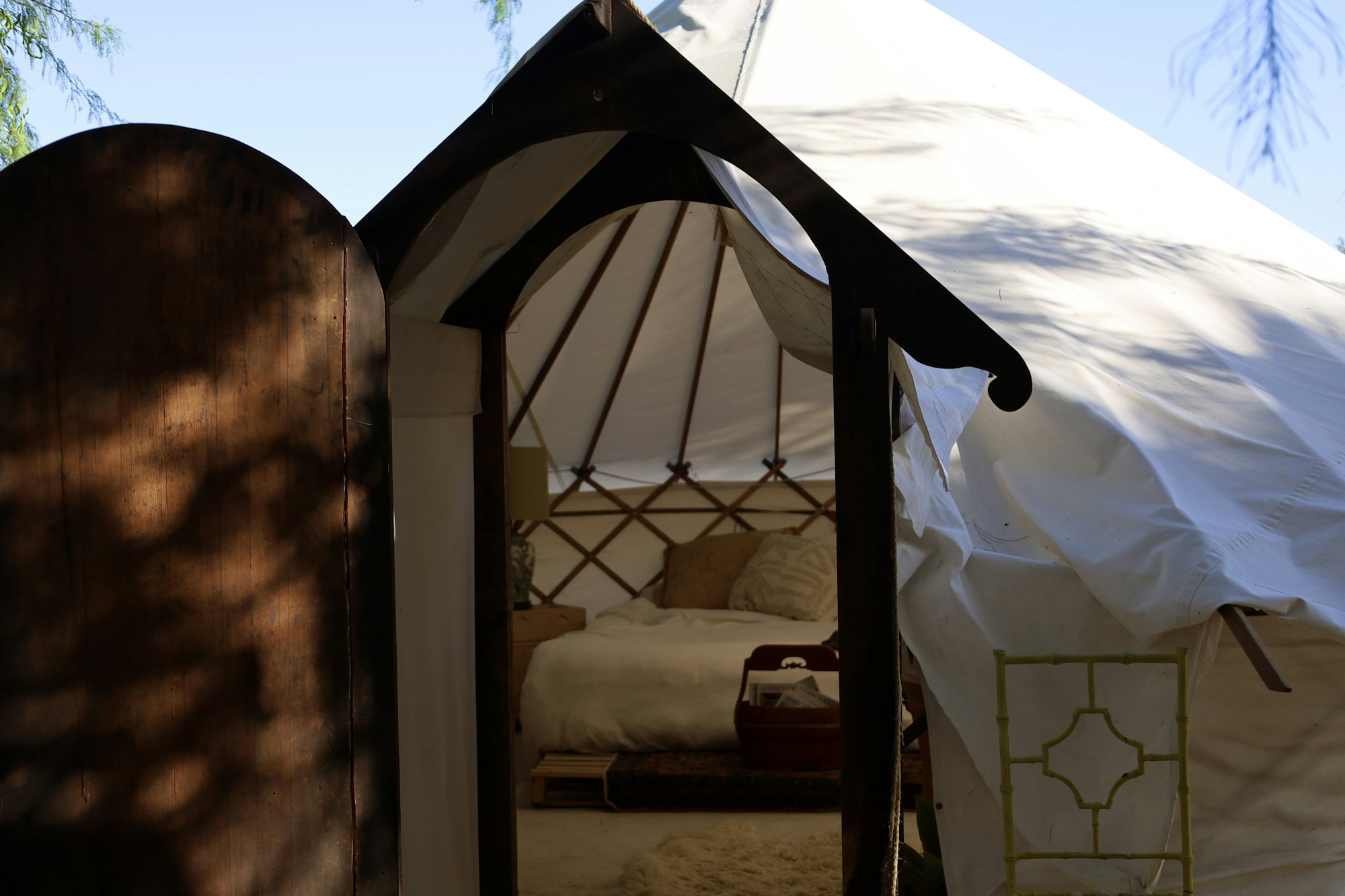 Interior of a luxury glamping tent with king-size bed and natural surroundings