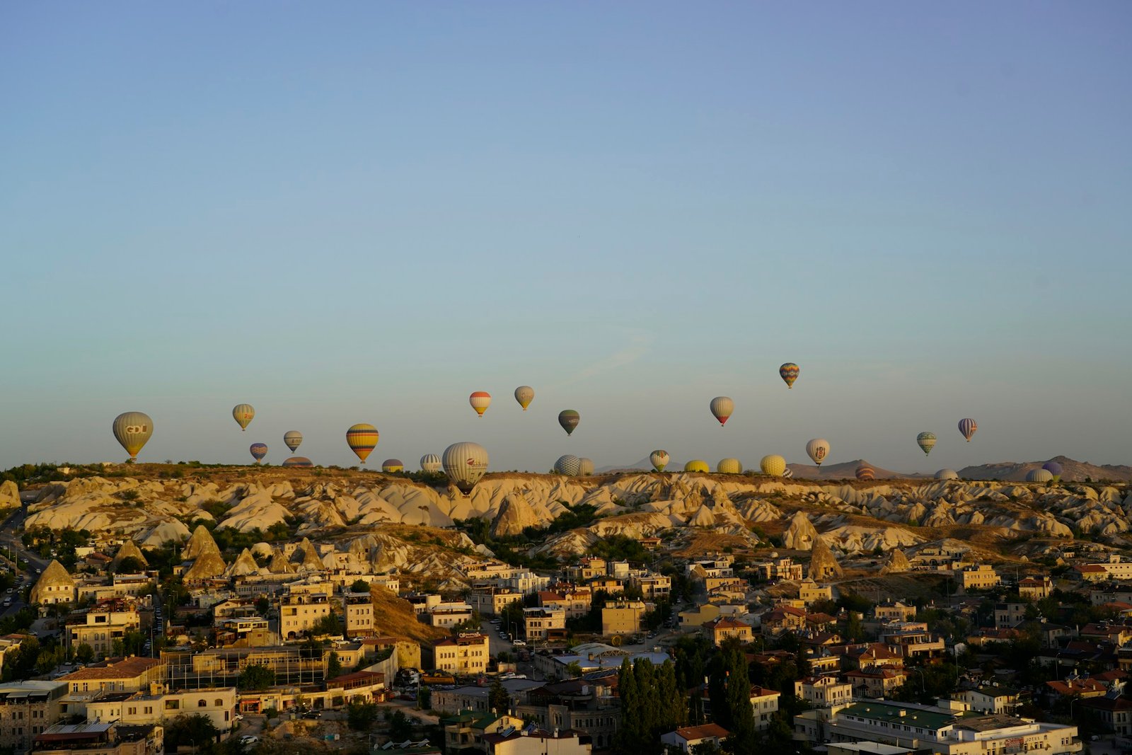 Hot air balloons flying over the fairy chimneys of Cappadocia at sunrise in Turkey