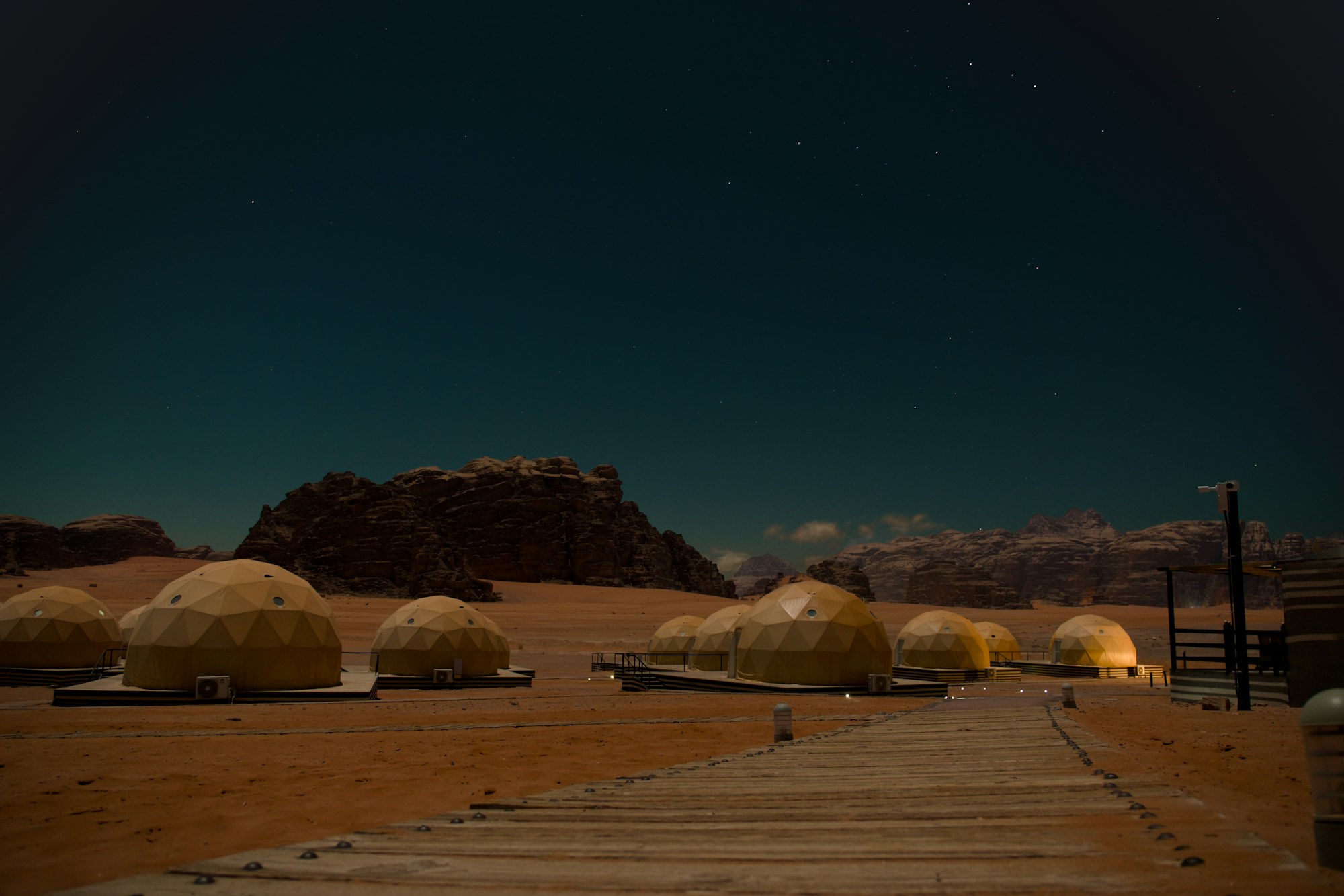 Glamping à Wadi Rum : campement de tentes transparentes sous un ciel étoilé dans le désert jordanien