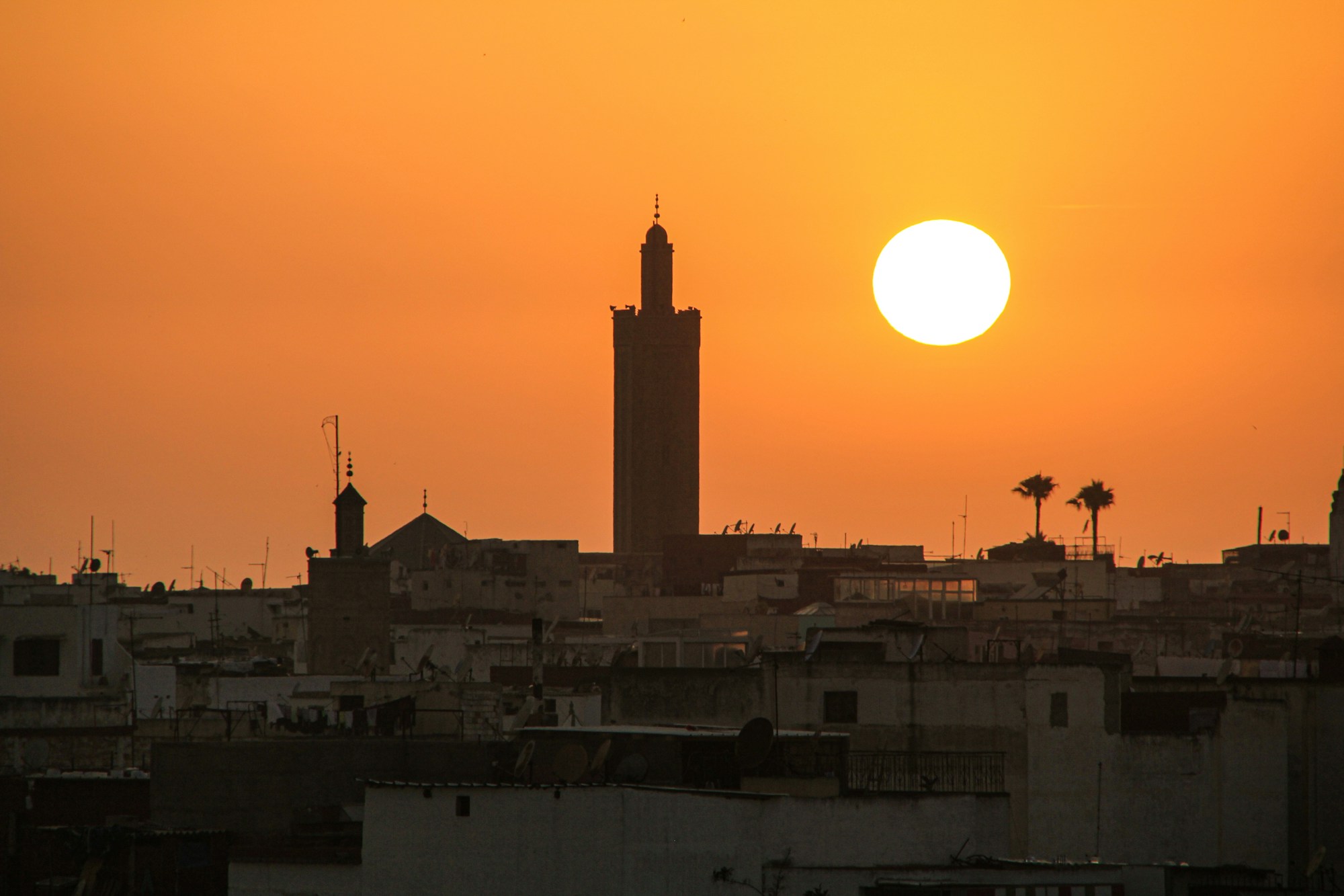 Tramonto su Rabat, capitale del Marocco, con le mura e i minareti che si stagliano sul cielo arancione