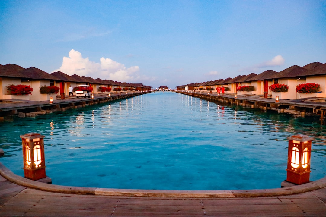 Overwater bungalows above a turquoise lagoon in the Maldives at sunset