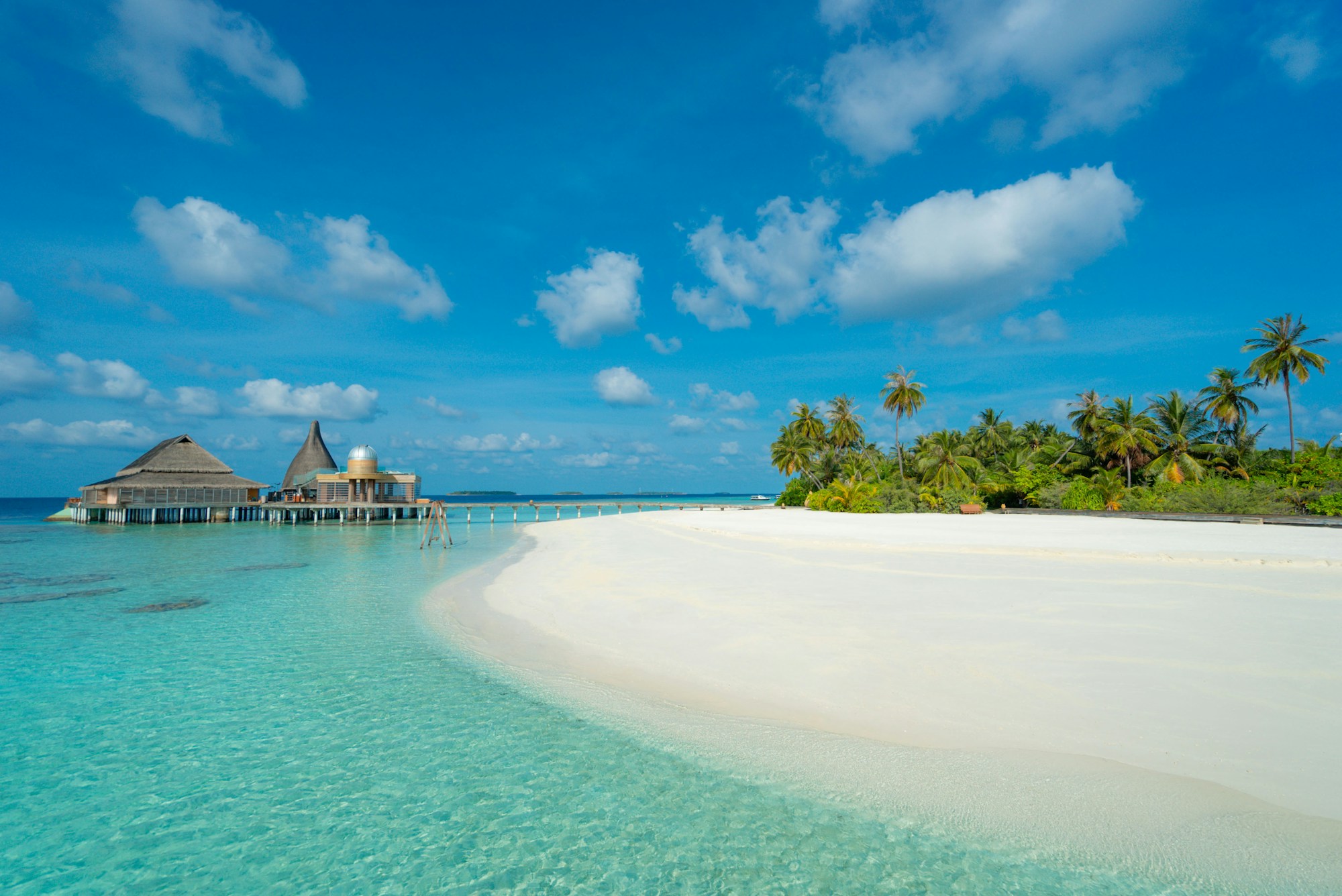 Overwater villa in the Maldives with turquoise lagoon and white sand beach