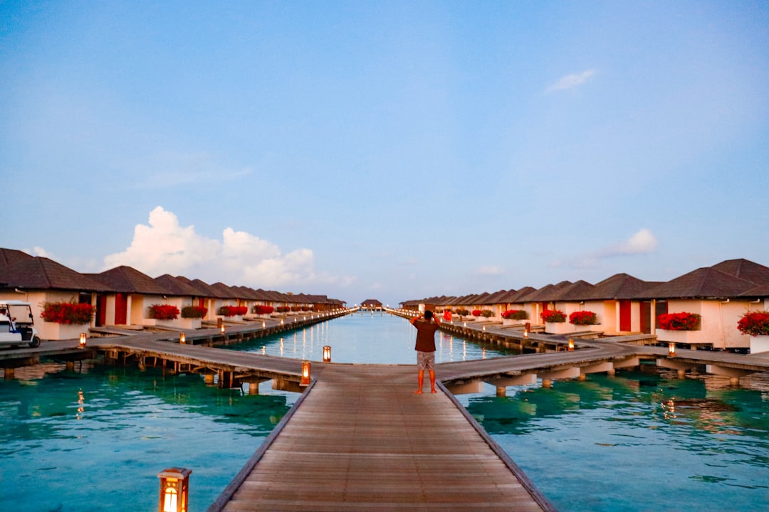 Luxury overwater villas with thatched roofs on a turquoise blue lagoon in the Maldives