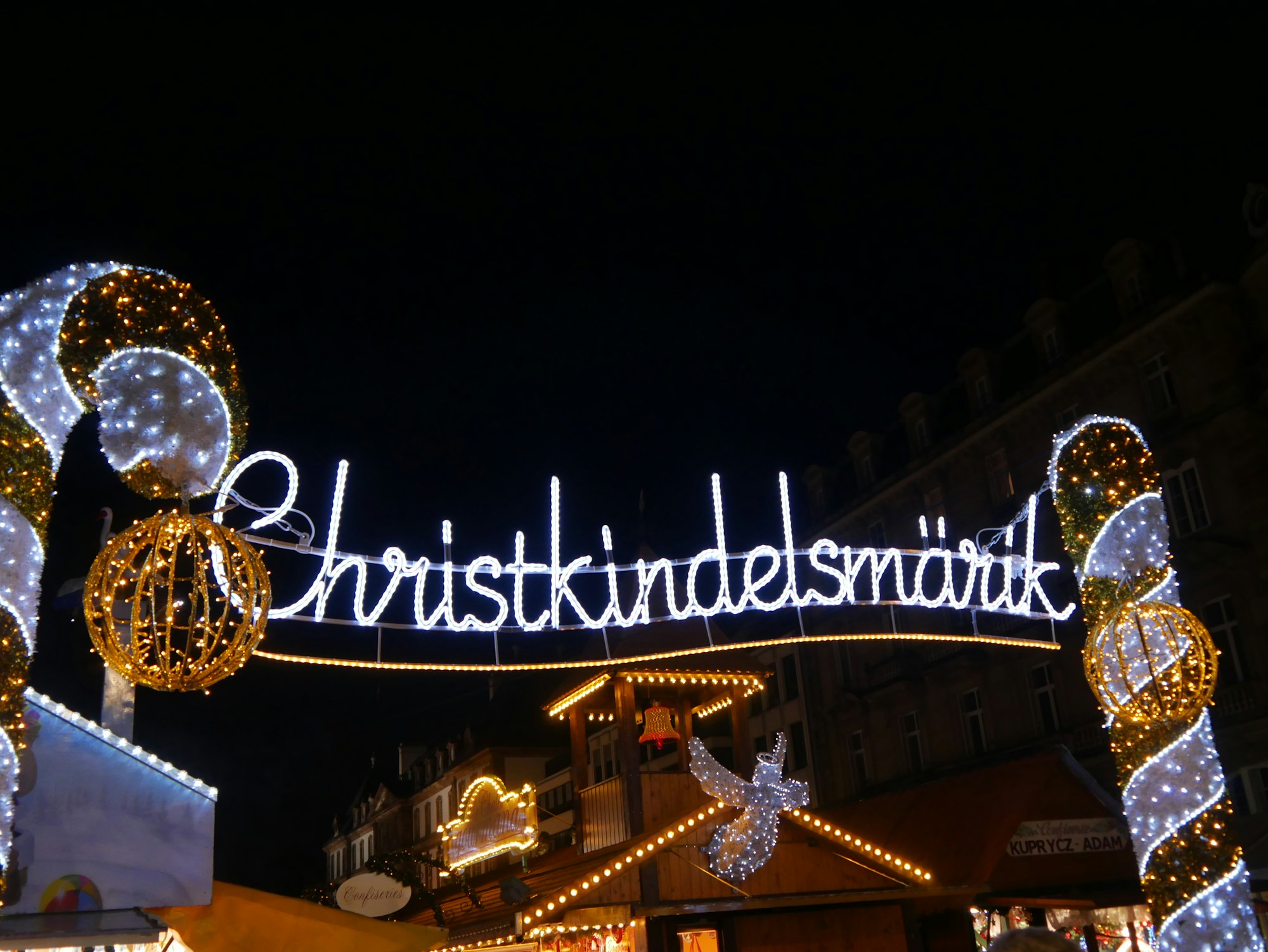 Illuminated Strasbourg Christmas Market with wooden chalets and the cathedral in the background