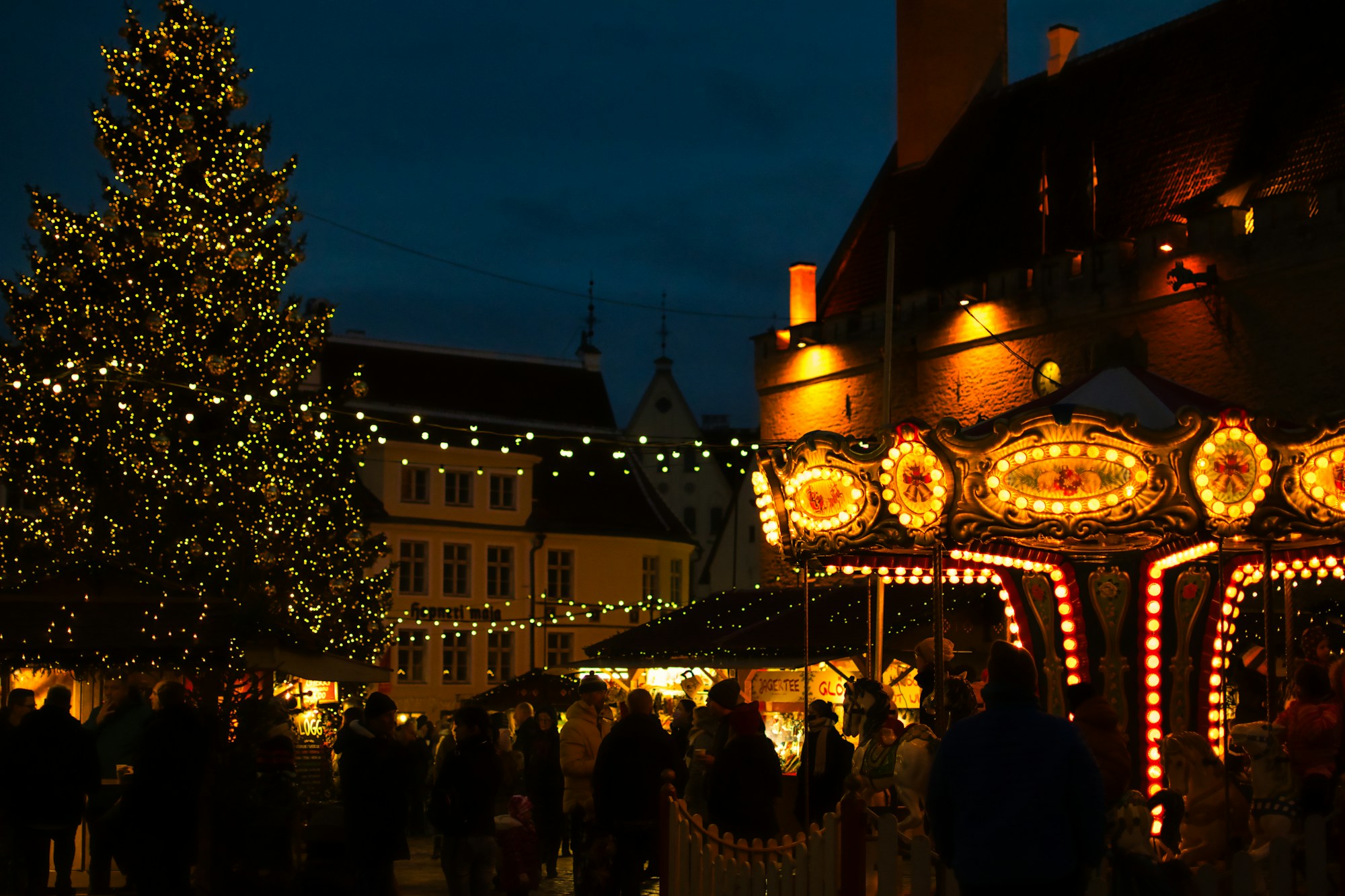 Tallinn Christmas Market on Town Hall Square with the illuminated tree and medieval chalets
