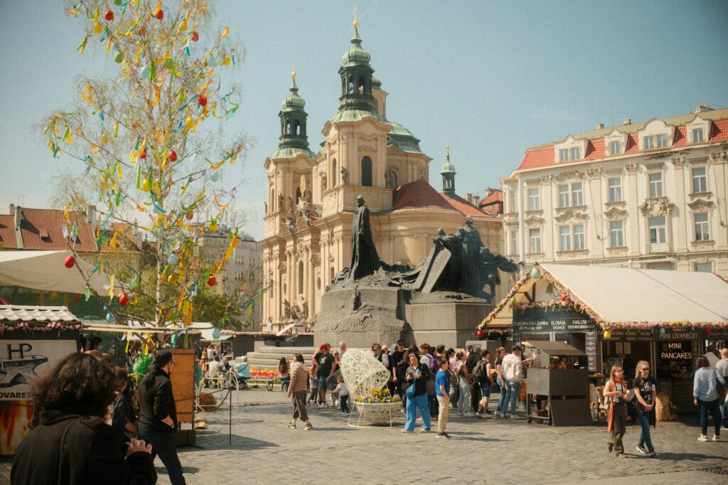 Foule sur la place de la Vieille-Ville de Prague avec des stands de marché de printemps et un arbre décoré par une belle journée ensoleillée
