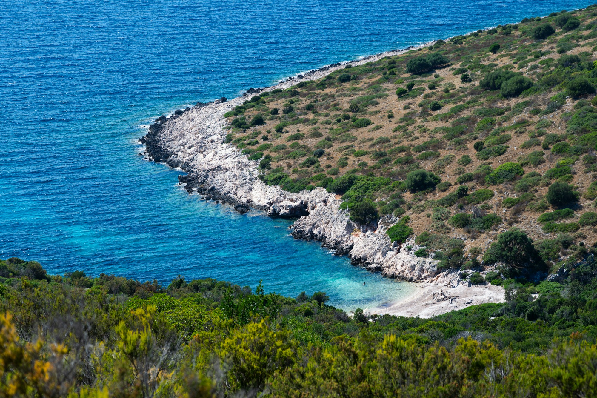 Turquoise cove tucked into the rocks of Sveti Jakov close to the walls of Dubrovnik, Croatia