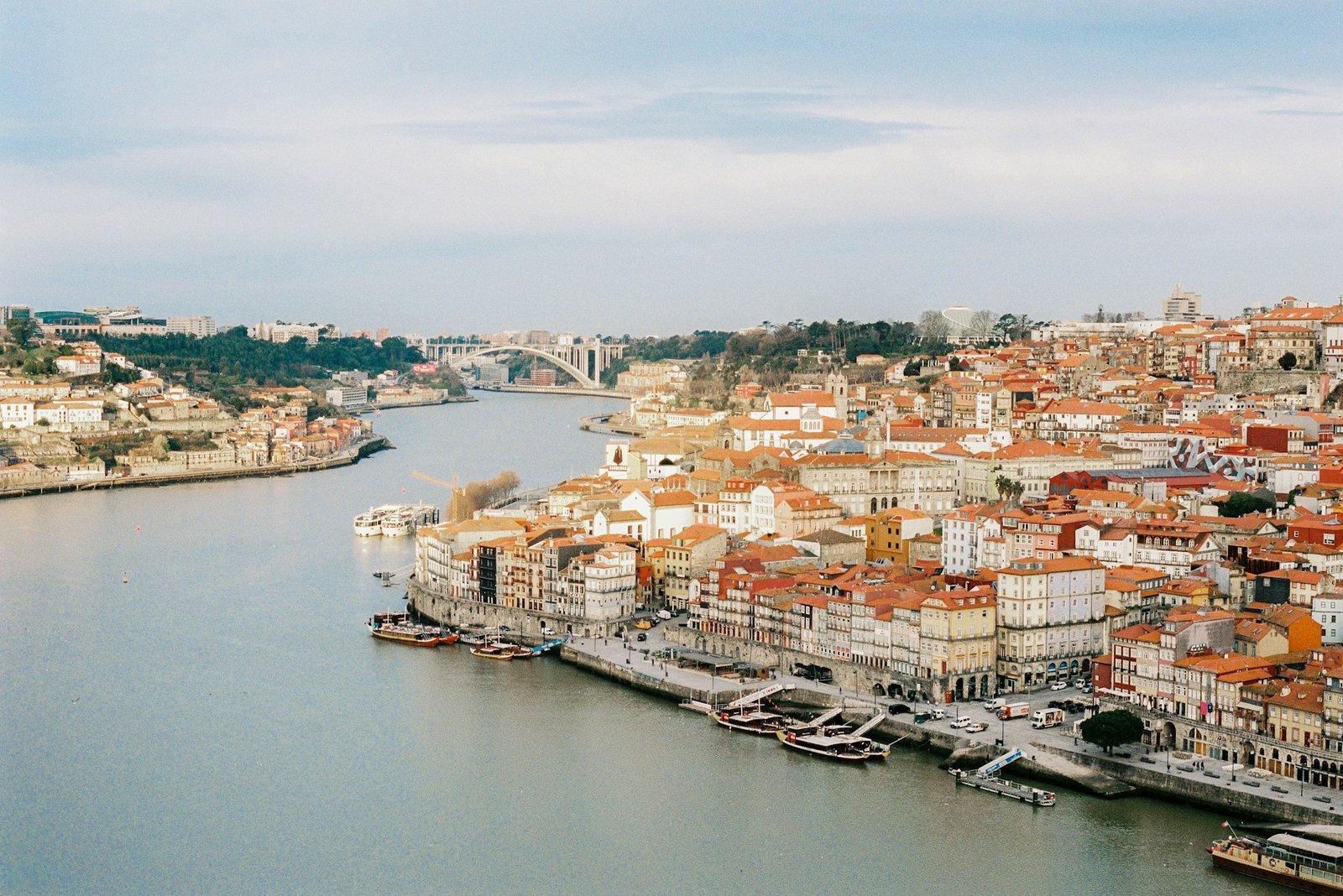 Sunrise over the Douro River in Porto with rabelo boats and the colourful houses of Ribeira
