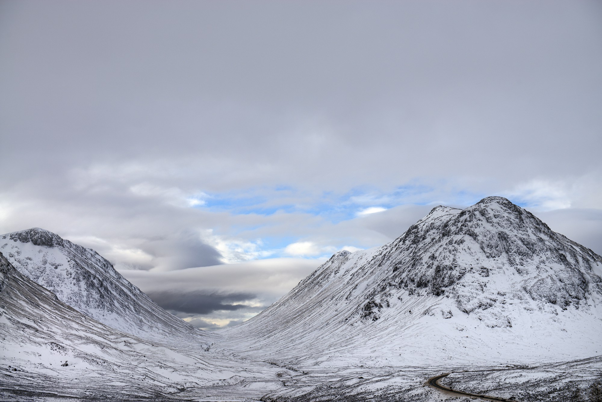 Vallée de Glencoe sous un ciel dramatique avec nuages bas et montagnes imposantes