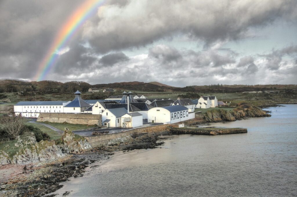 Distillerie de whisky écossais avec arc-en-ciel et ciel nuageux dramatique