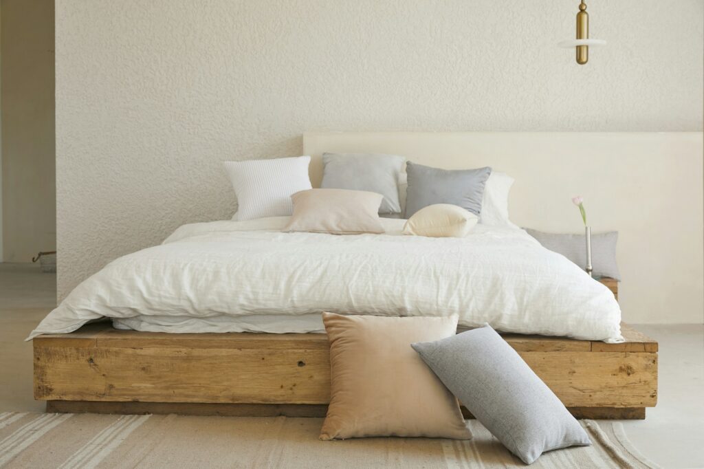 Oreiller de lit blanc sur cadre de lit en bois brun