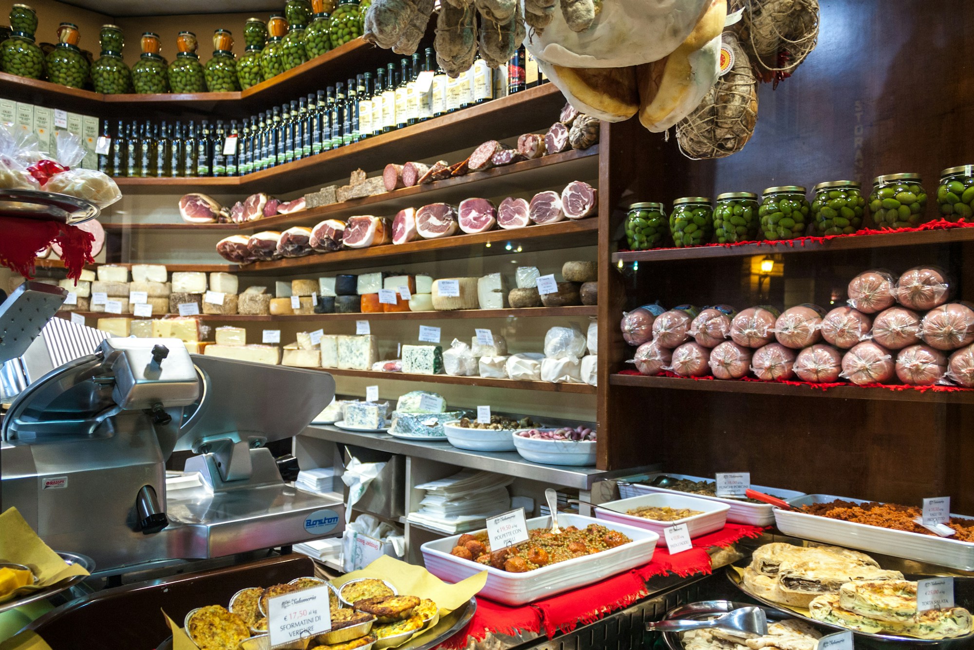 Comptoir d'une épicerie fine italienne avec charcuteries et fromages artisanaux