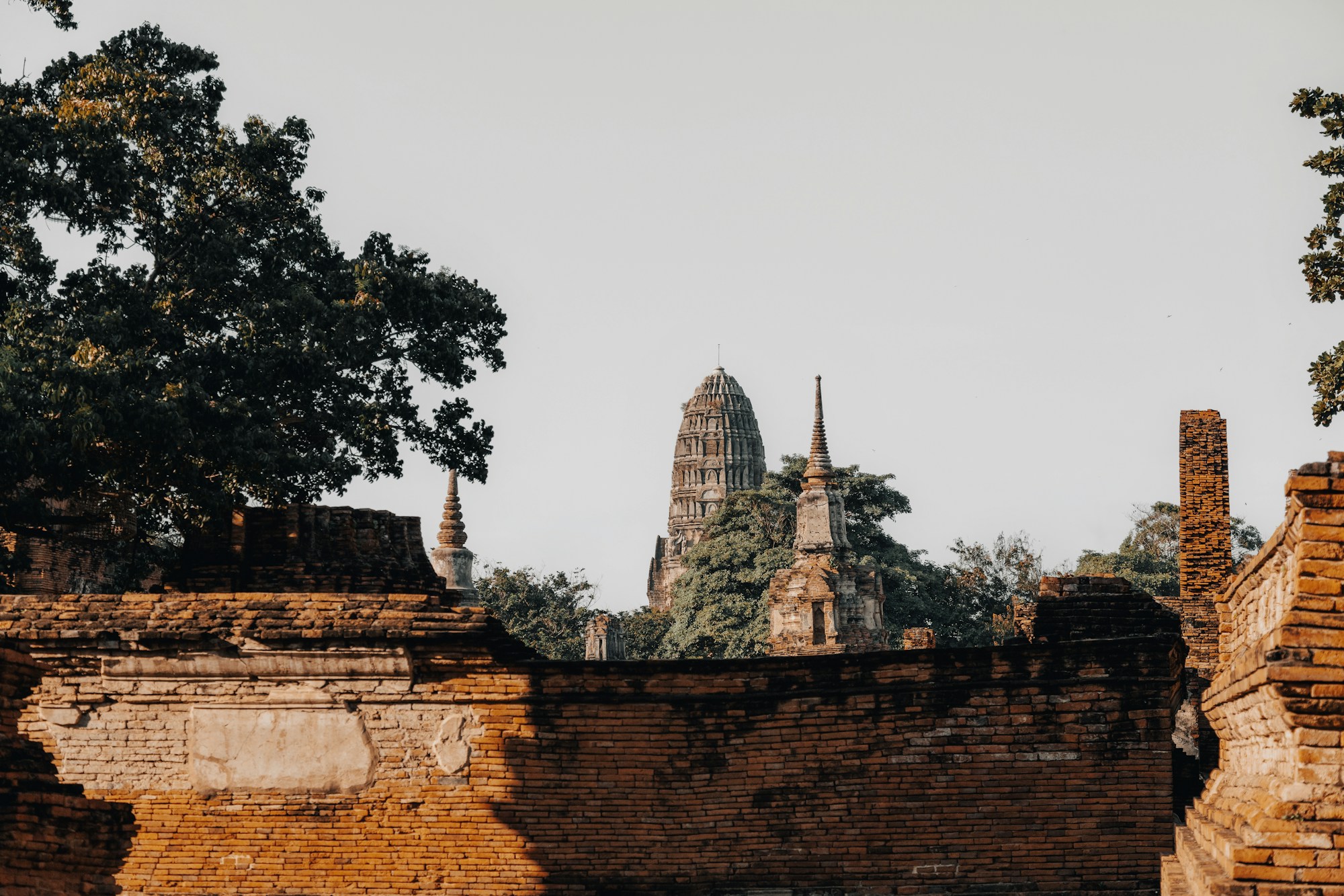 Ruines des temples d'Ayutthaya avec stoupas de briques rouges sous un ciel nuageux, ancienne capitale du Royaume de Siam