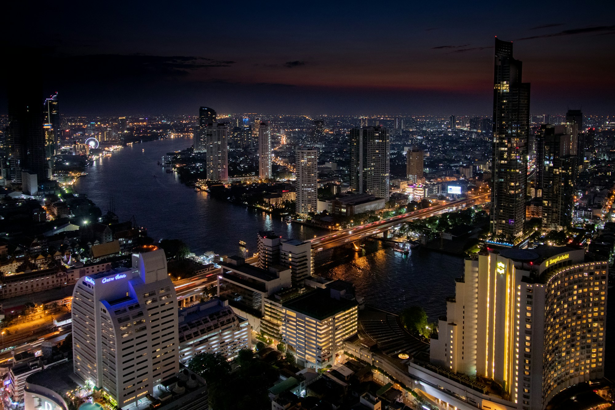 Panorama nocturne de Bangkok avec ses gratte-ciels illuminés reflétés dans la Chao Phraya