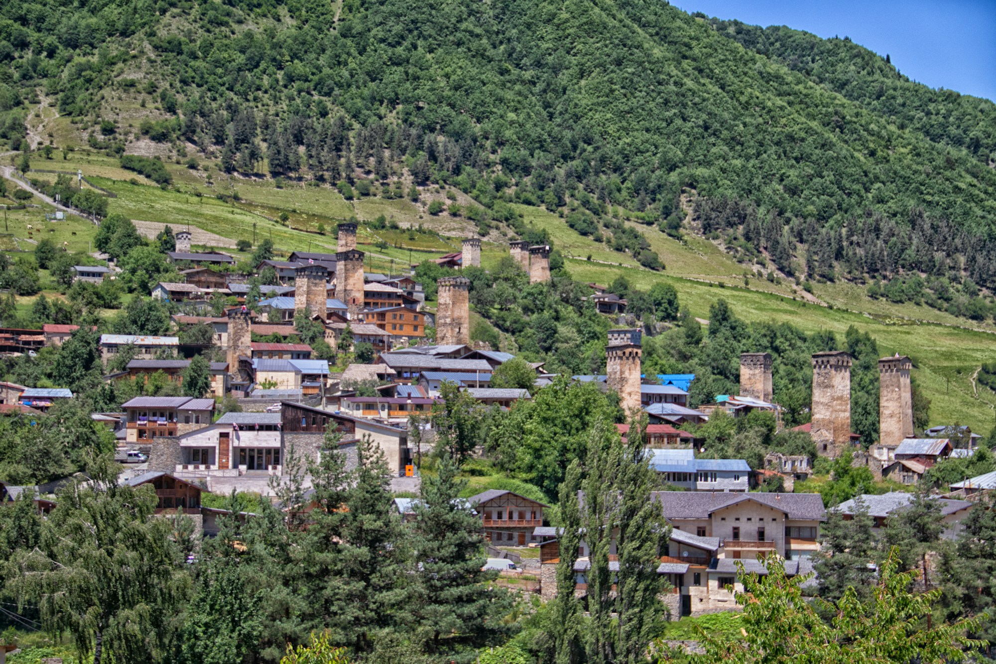 Dorf Mestia in Swanetien, Georgien, mit mittelalterlichen Wehrtuermen und den Bergen des Kaukasus