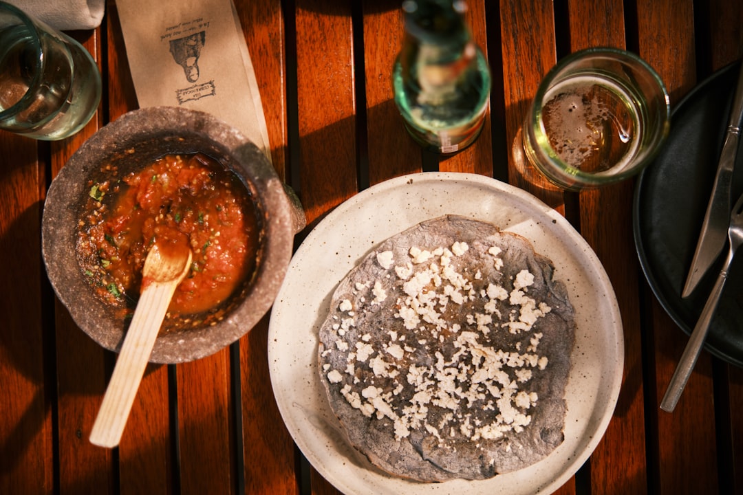 Colorful Mexican dish with fresh vegetables and sauces on a wooden table in Oaxaca