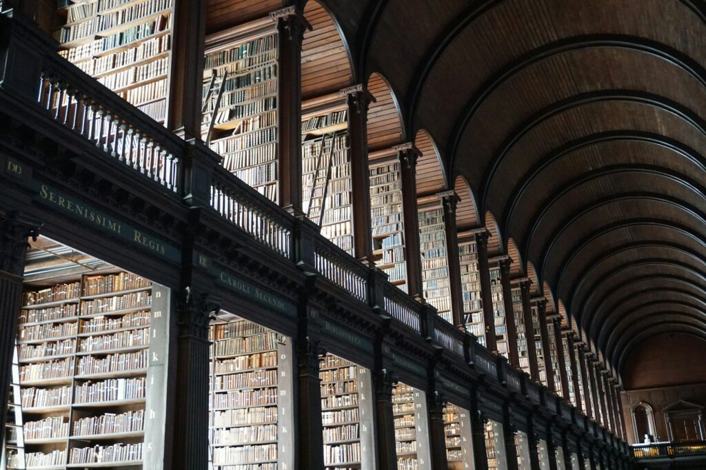 Intérieur majestueux de la bibliothèque du Trinity College à Dublin avec ses voûtes en bois et ses milliers de livres anciens