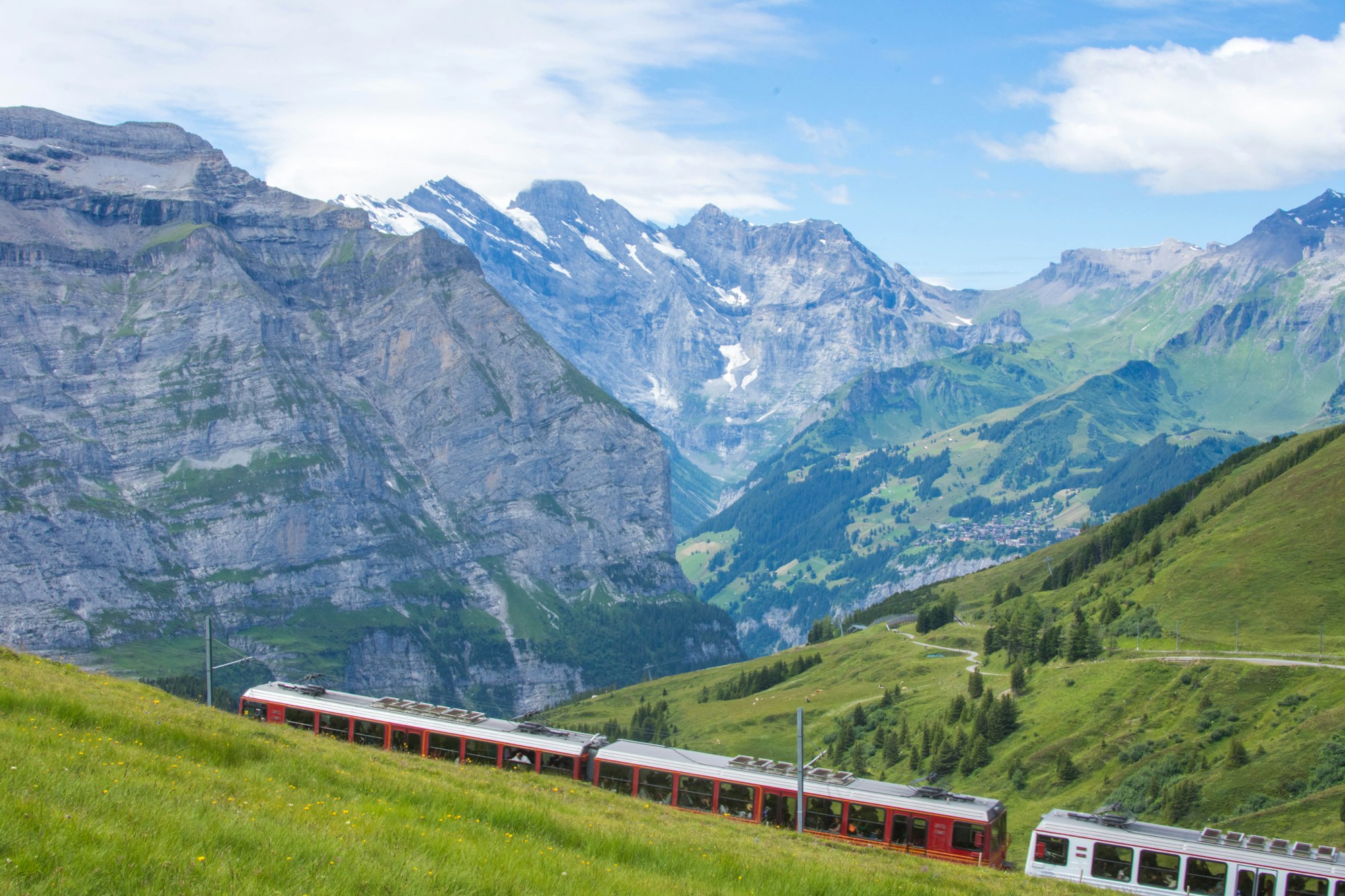 Paesaggio alpino svizzero con treno che attraversa le montagne innevate