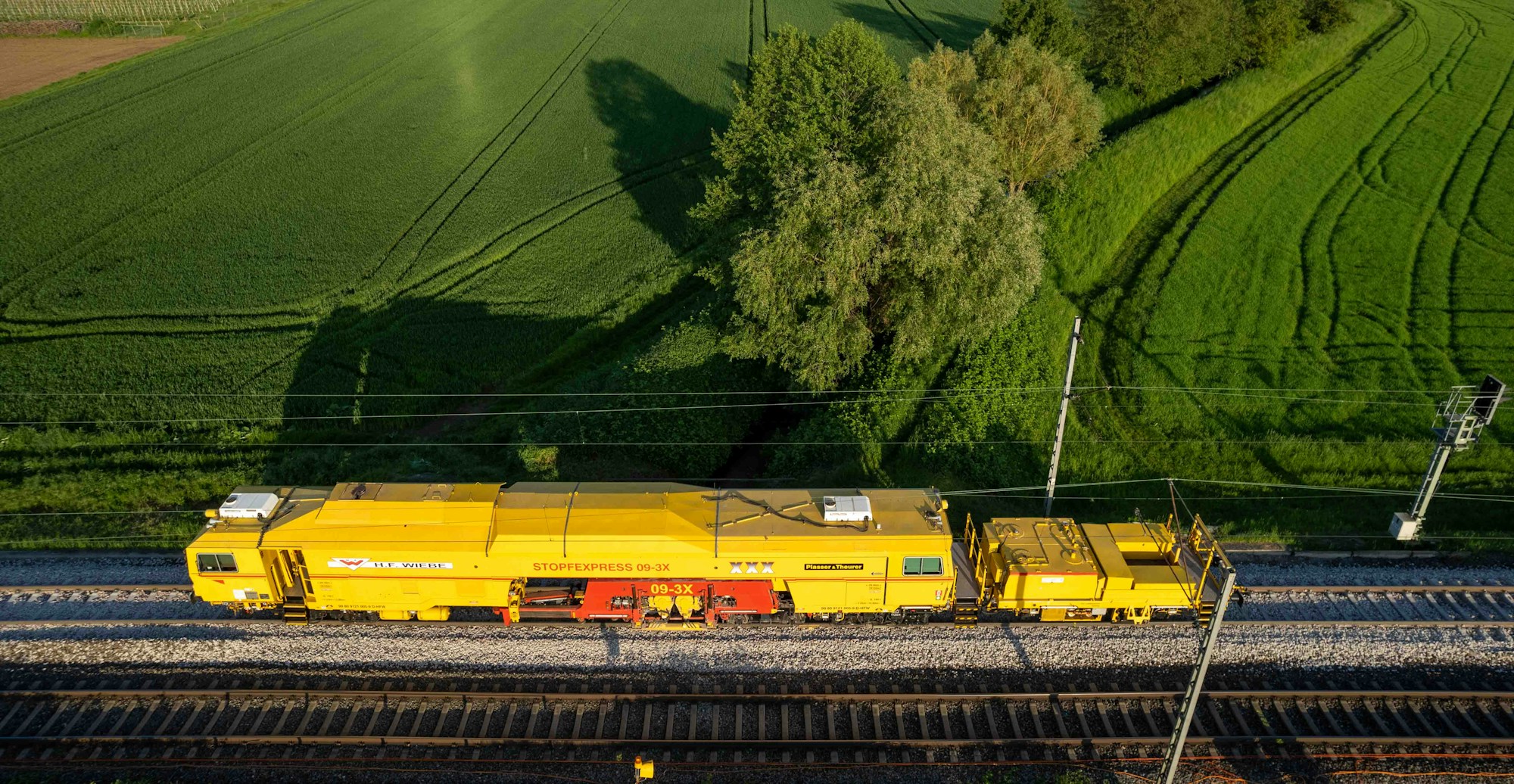 Train jaune traversant la campagne européenne au coucher du soleil