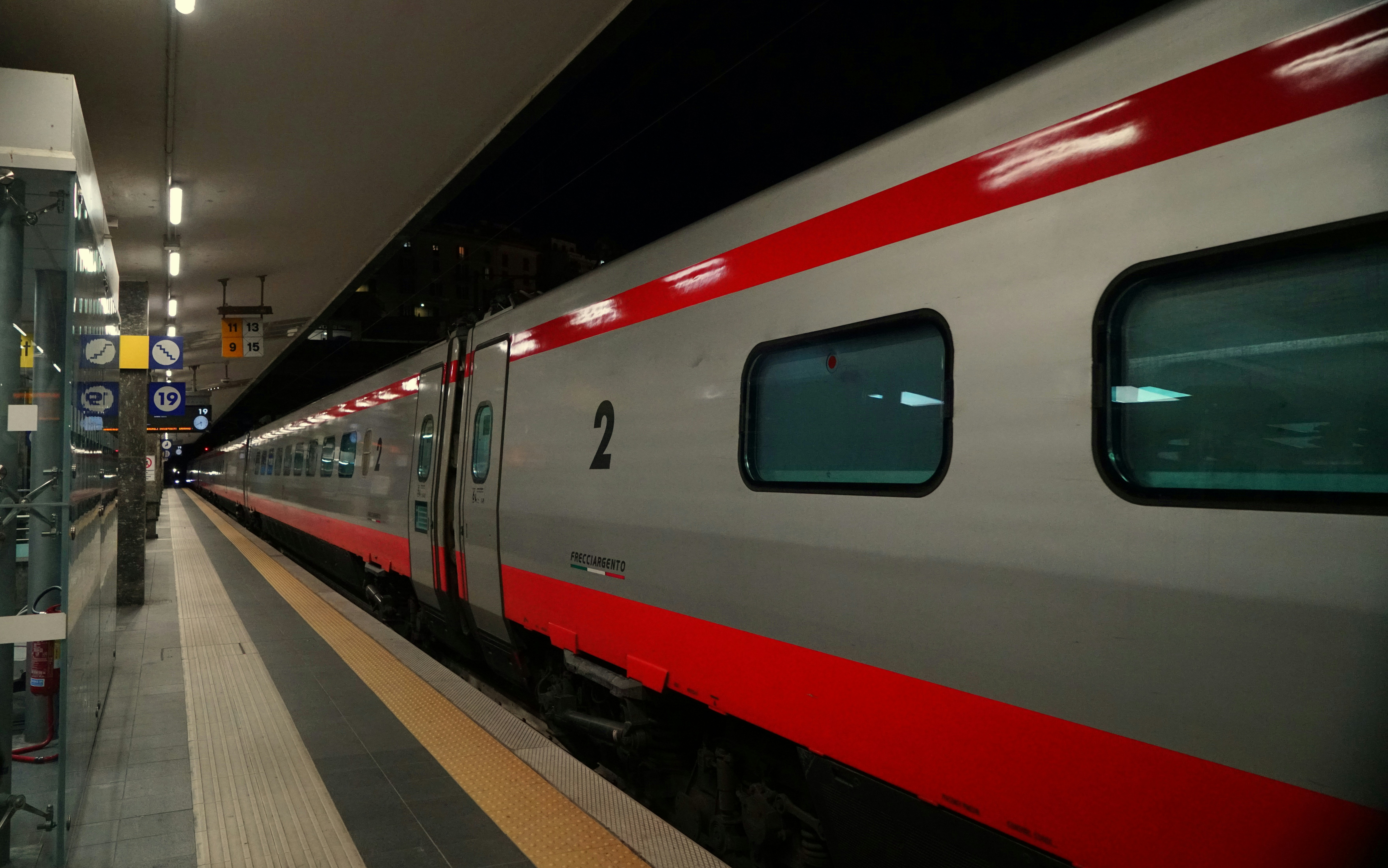 European train passing through a station at dusk