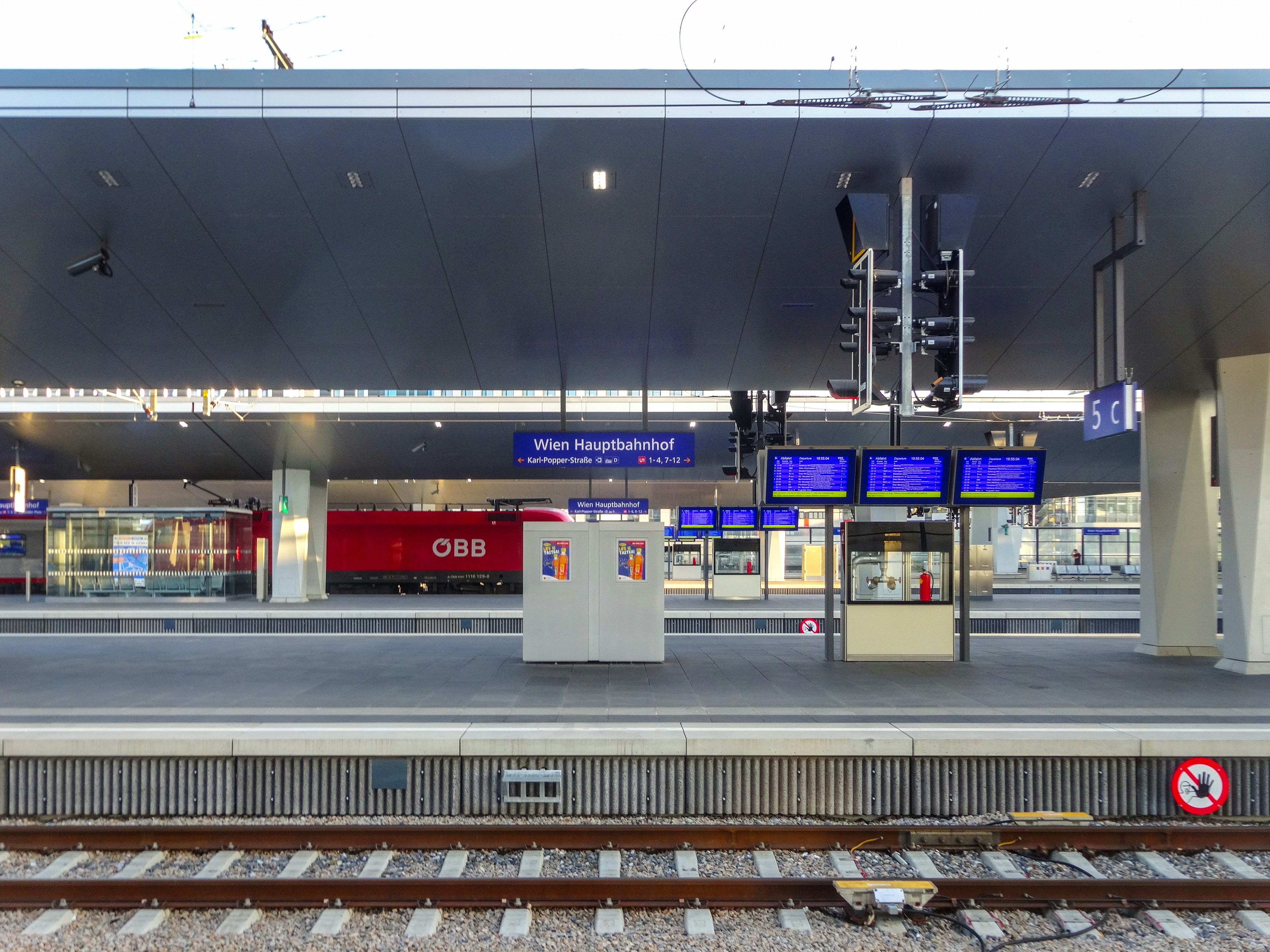 Modern station platform with digital displays and ÖBB train