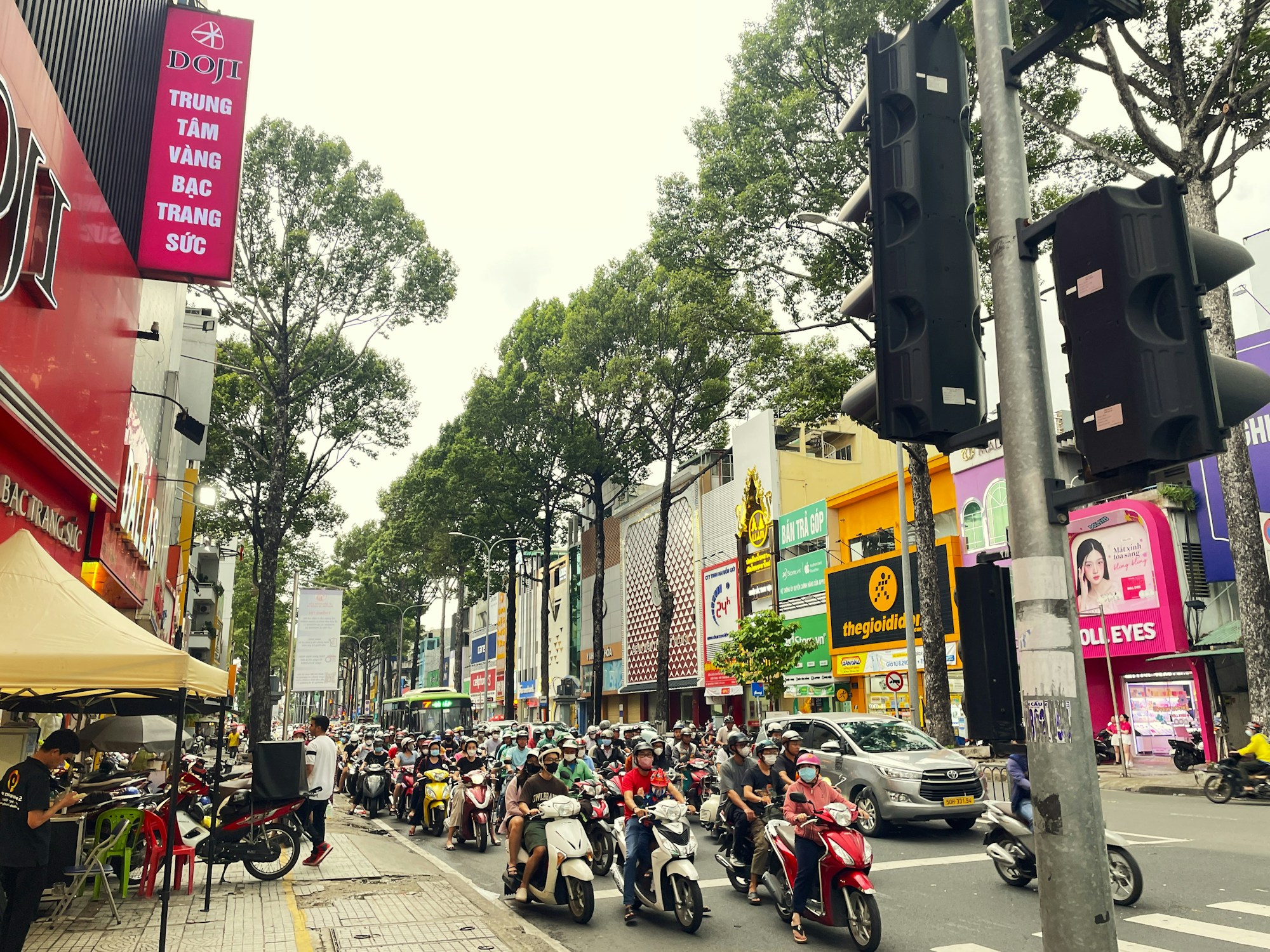 Rue animée de Hô Chi Minh-Ville avec scooters et enseignes lumineuses