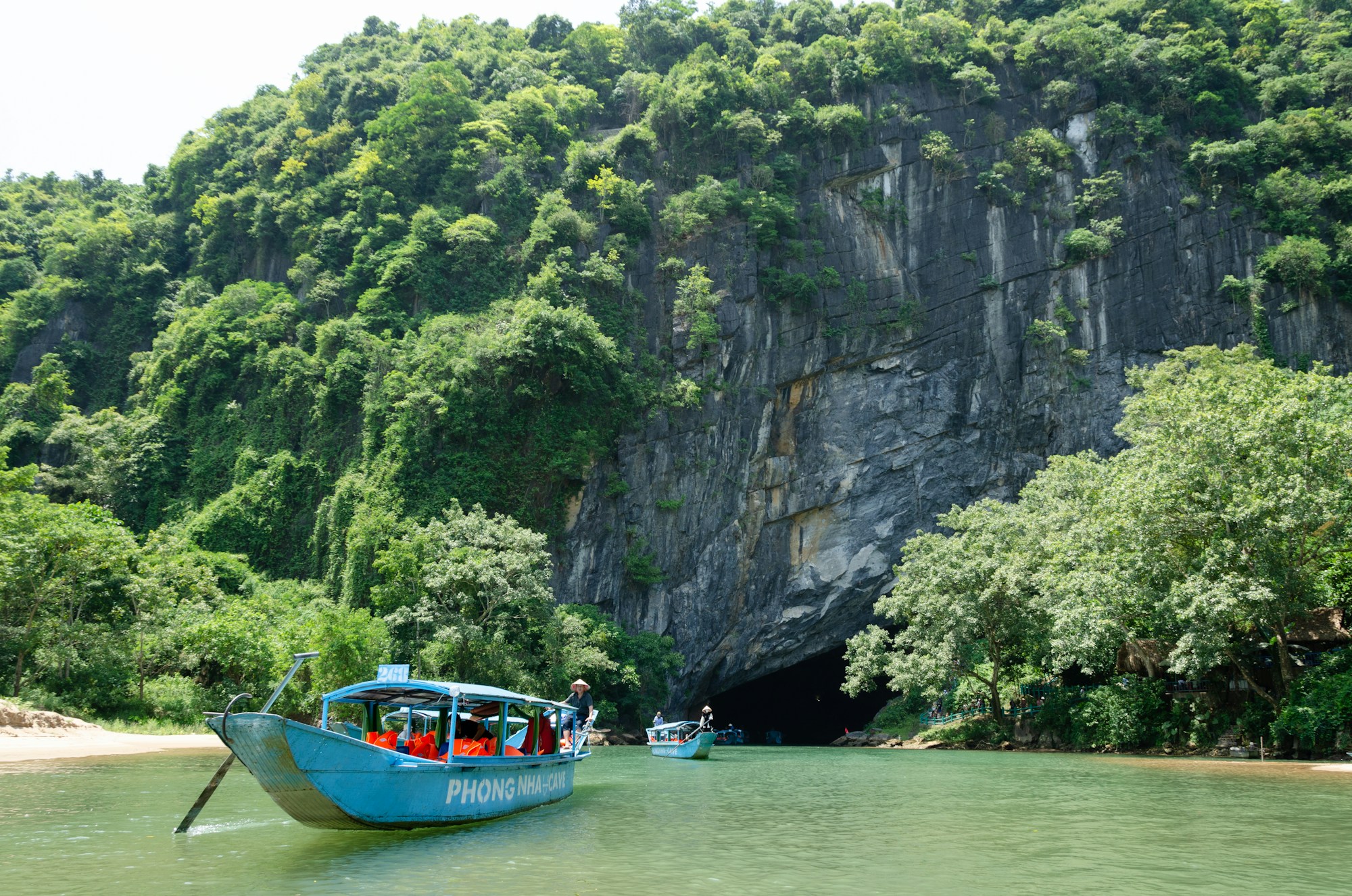 Entrée illuminée de la grotte de Phong Nha avec rivière souterraine