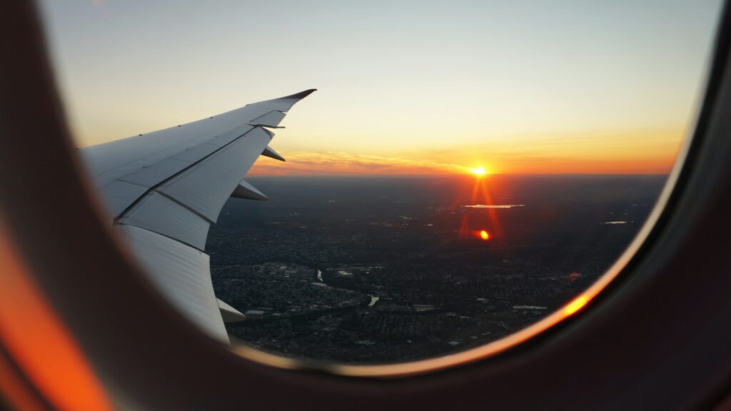 Vue depuis le hublot d'un avion au coucher du soleil pendant un vol long-courrier