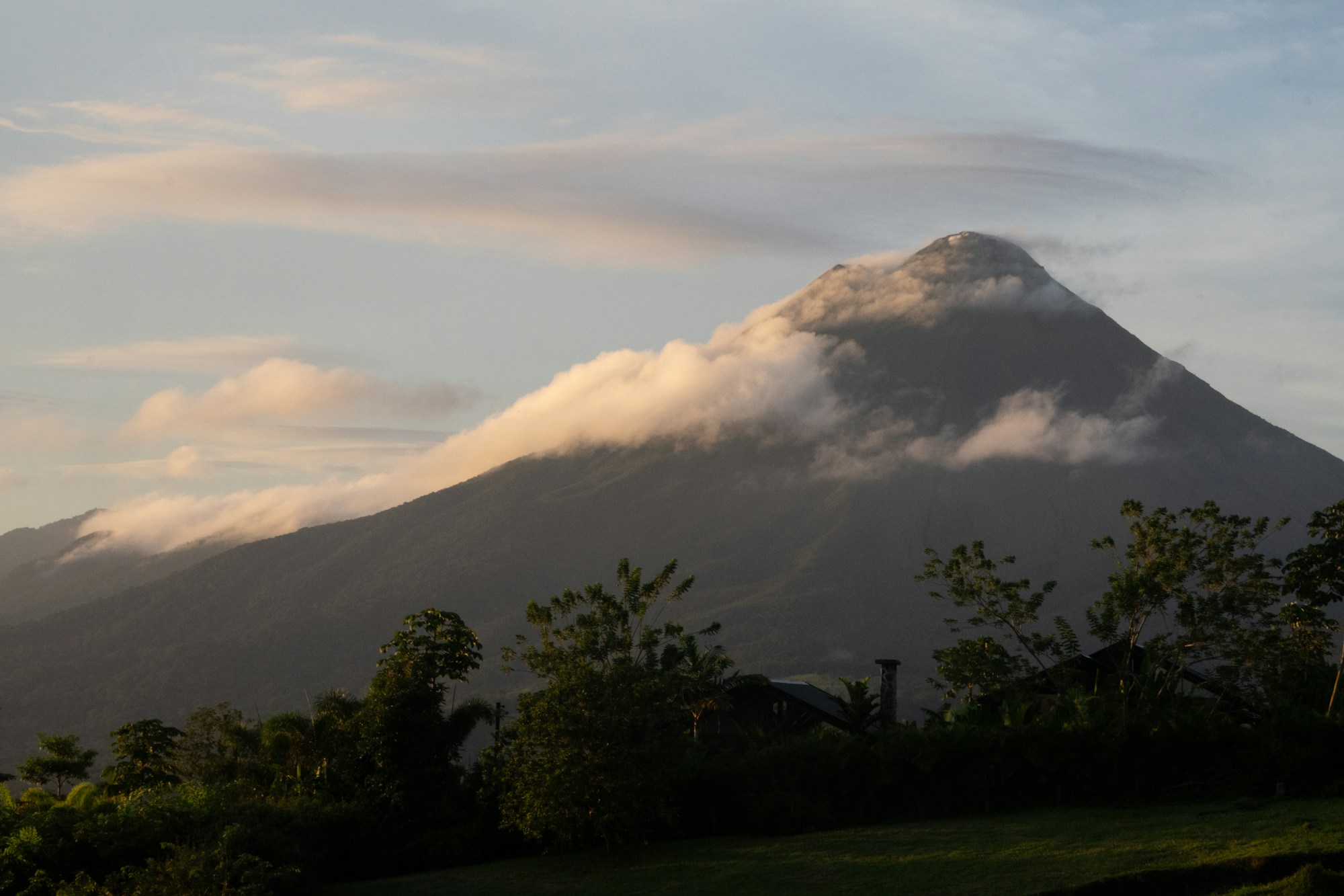Arenal Volcano in Costa Rica surrounded by clouds at sunrise