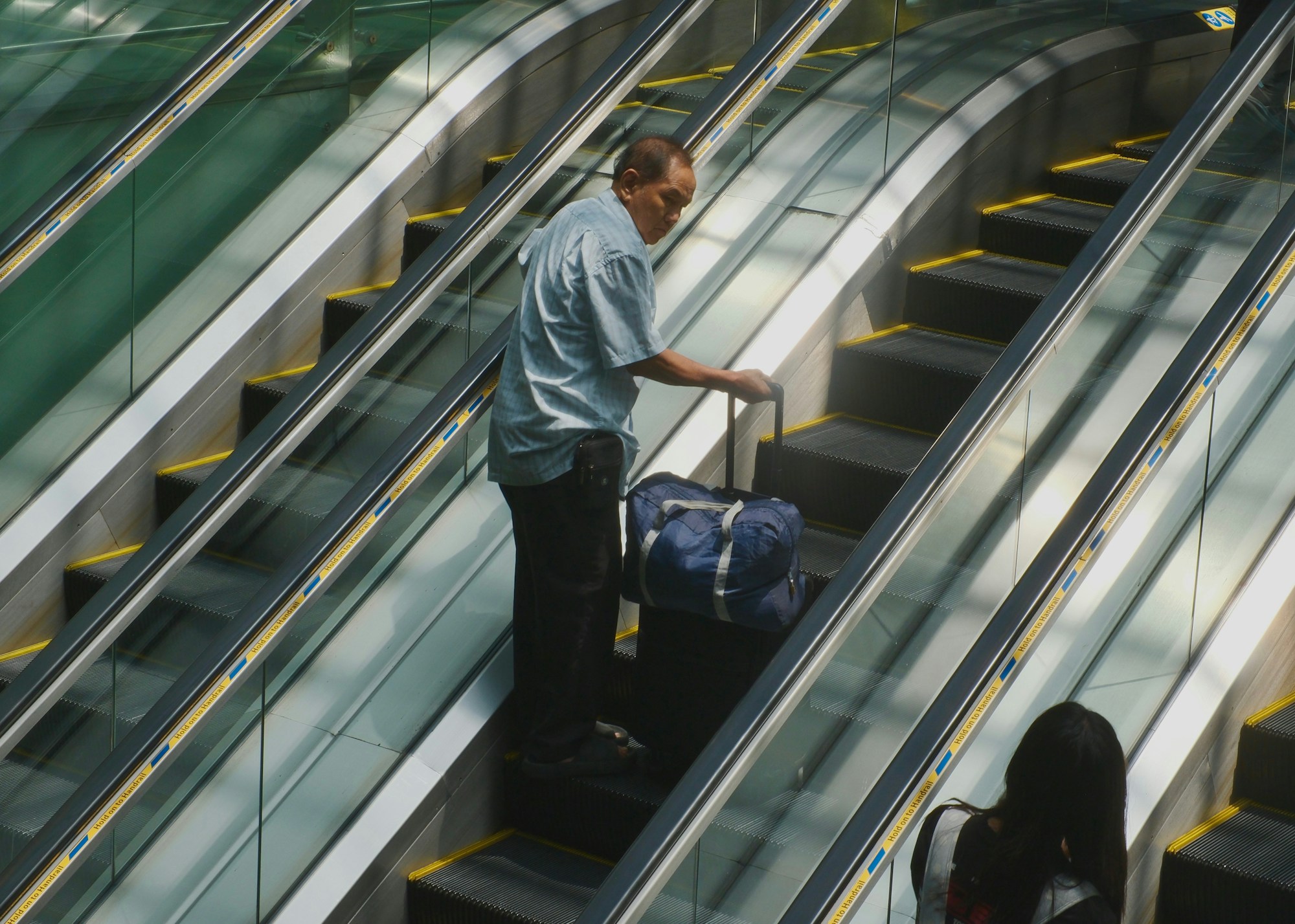 Voyageur avec ses bagages sur un escalator d'aéroport : profils de voyageurs