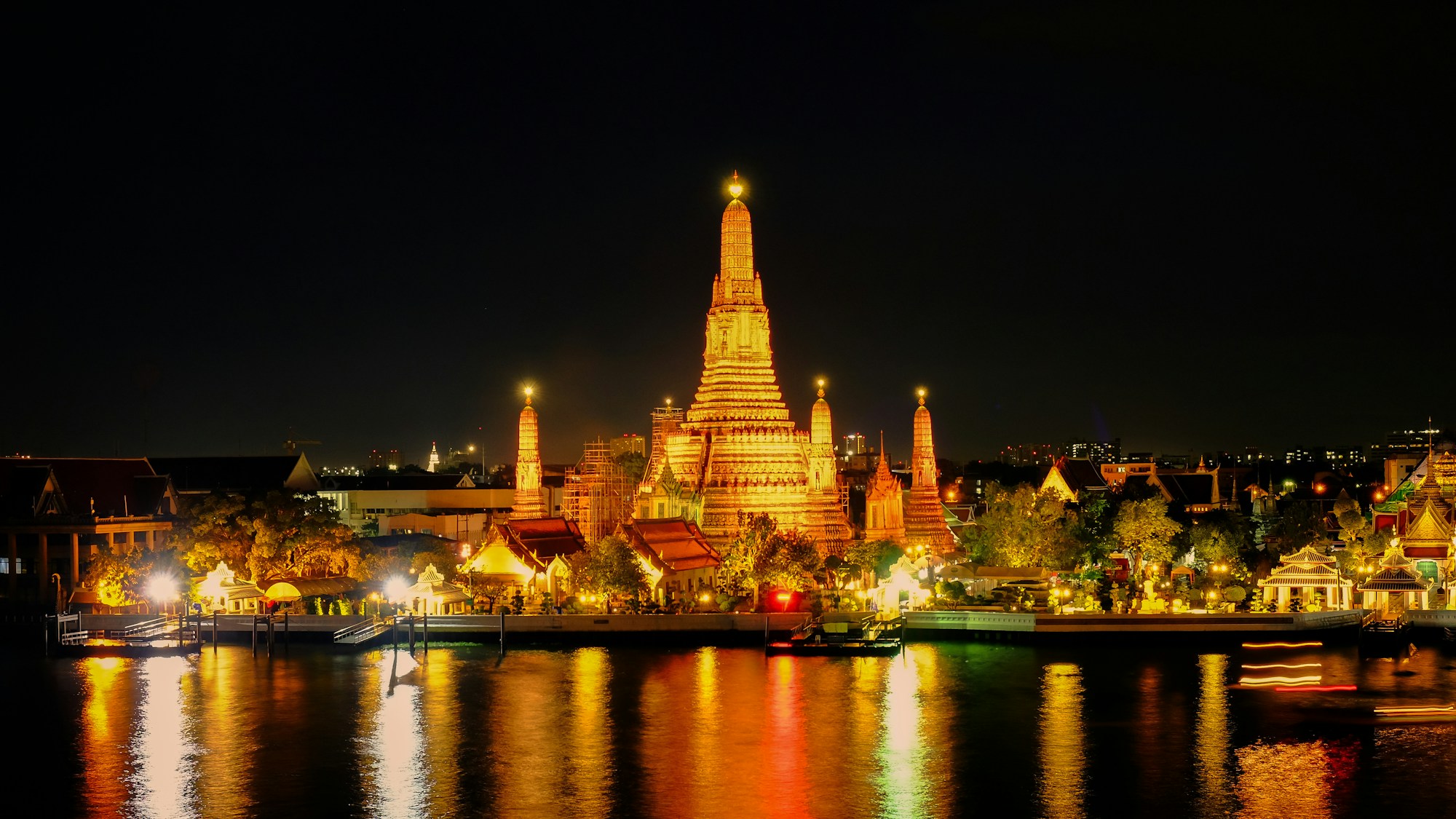 Temple de Bangkok illuminé la nuit avec reflets sur le fleuve Chao Phraya, Thaïlande