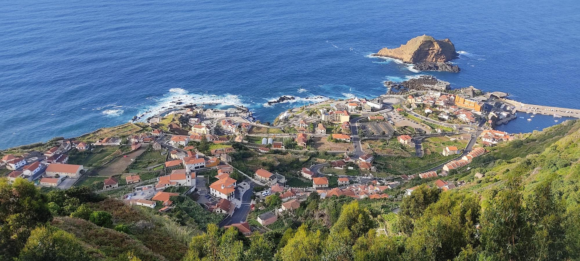 Luftaufnahme des Küstendorfes Porto Moniz auf Madeira, Portugal, mit den natürlichen Lavapools und den Häusern mit roten Dächern