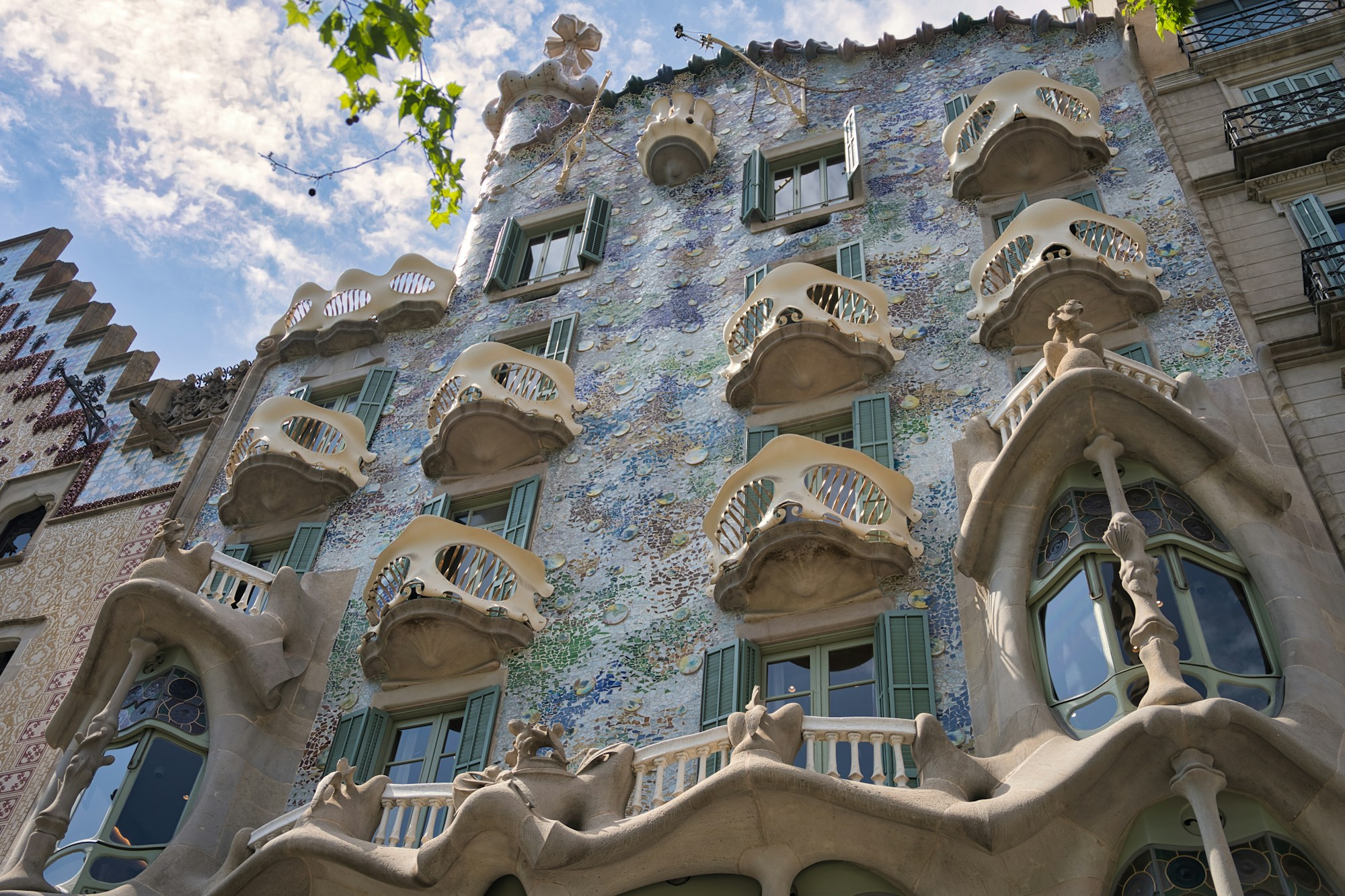 The façade of Antoni Gaudí's Casa Batlló on Passeig de Gràcia in Barcelona, with its iconic rooftop sculptures