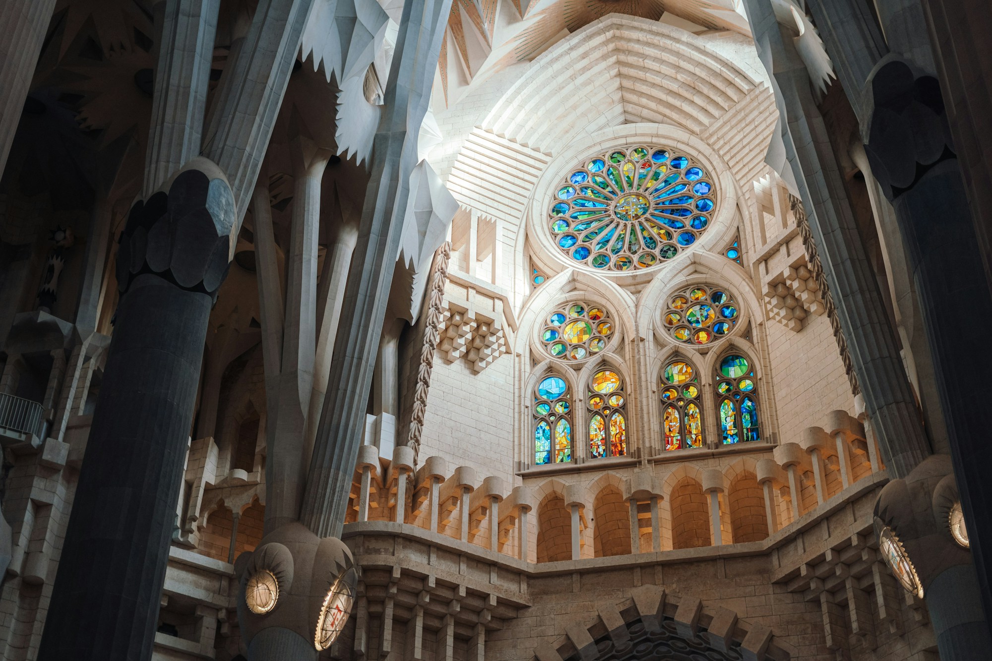Interior of the Sagrada Família with multicolored stained glass windows flooding the nave with light