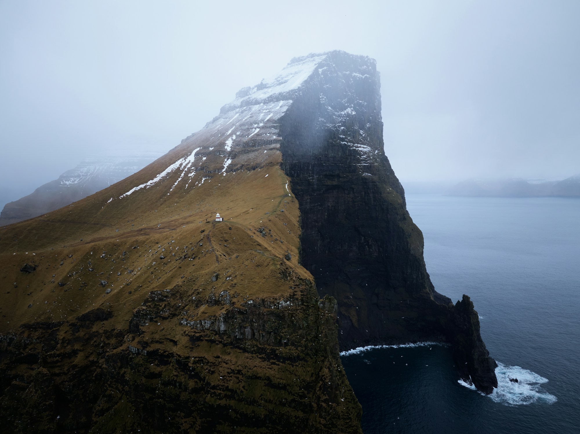 Le célèbre phare de Kallur sur l'île de Kalsoy aux Îles Féroé, perché sur une falaise vertigineuse surplombant l'Atlantique