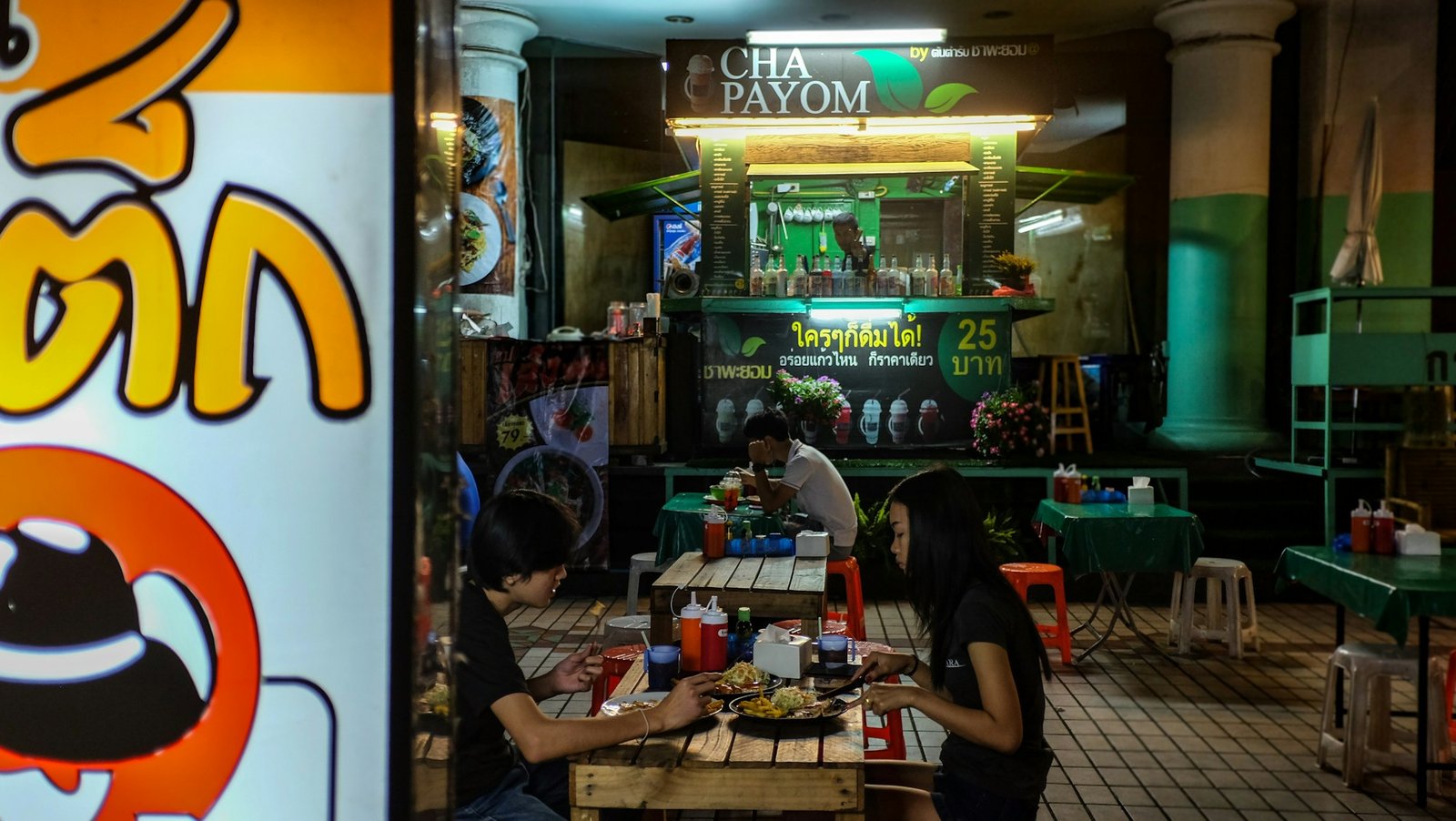 Traditional Thai street food scene with seated customers in Bangkok