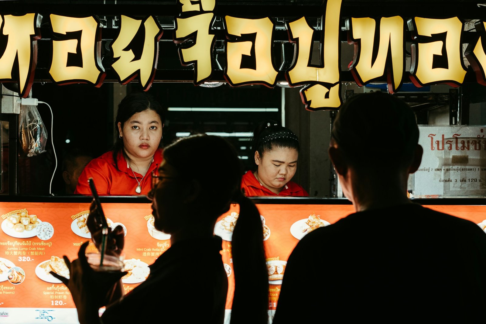 Bangkok night market with illuminated food stalls and local crowd