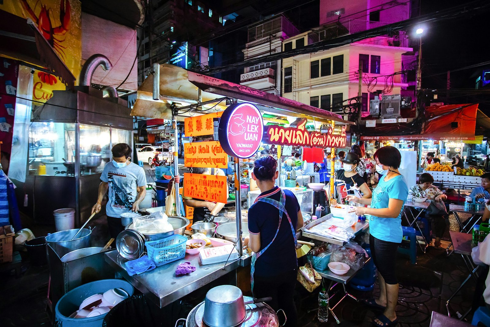 Street food stall in Bangkok's Chinatown with noodles and skewers