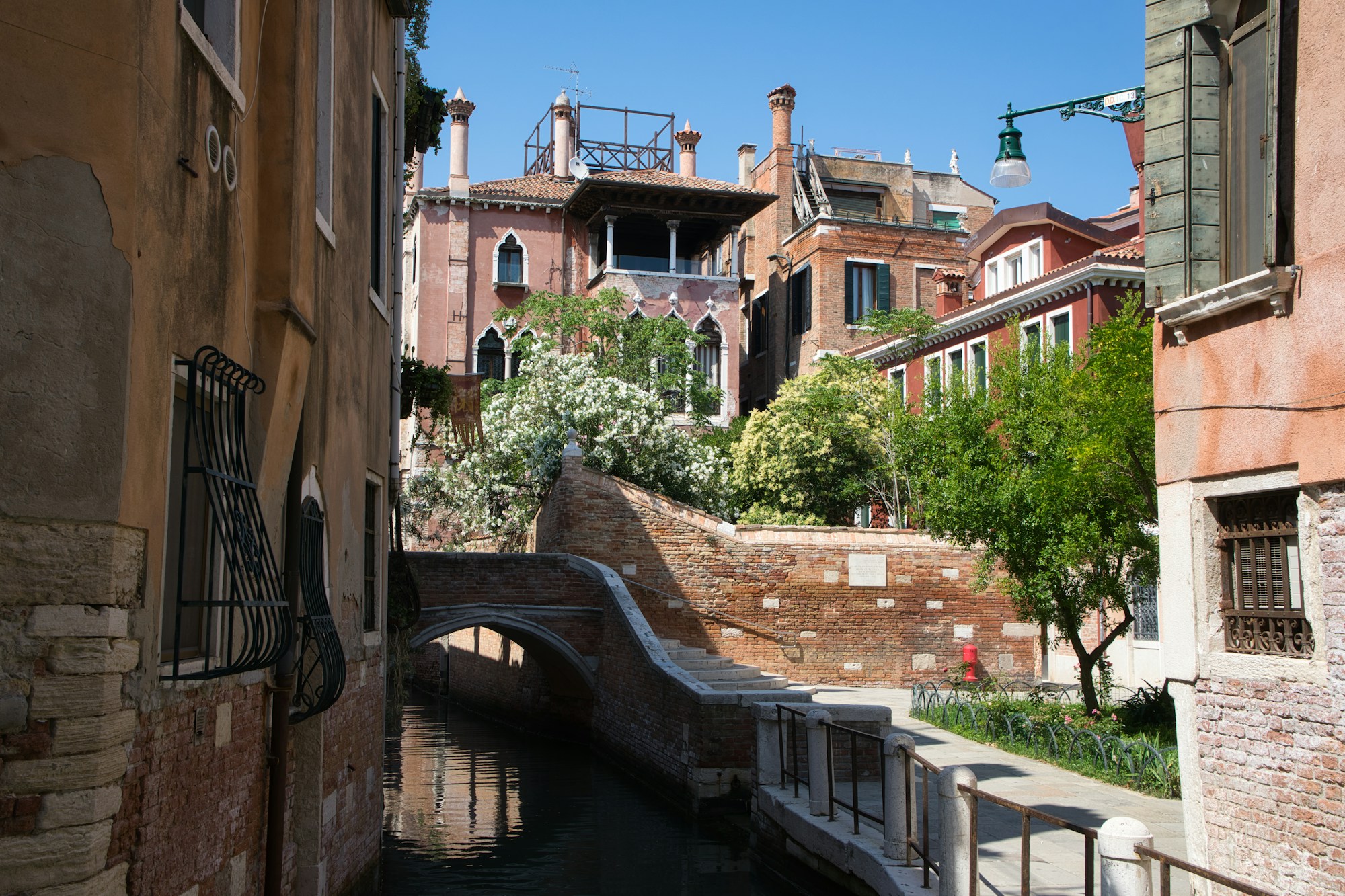 Vista de un canal veneciano con antiguos edificios de ladrillo y fachadas en colores pastel