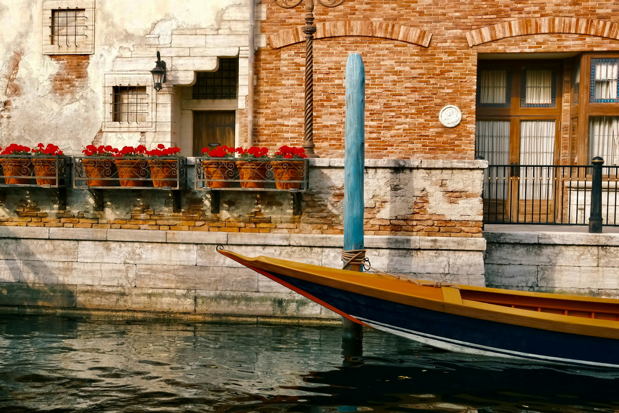 Góndola tradicional en un canal veneciano, fachadas coloridas y reflejos en el agua